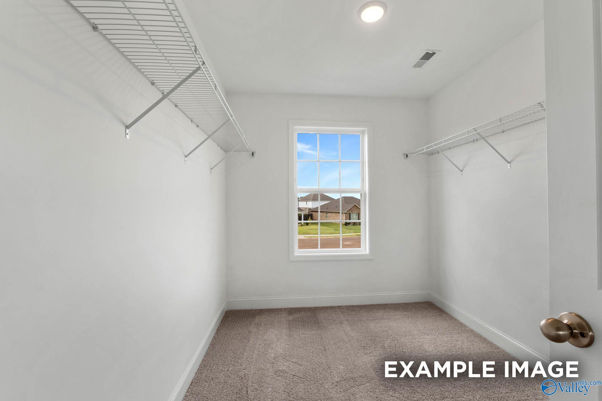 Spacious walk-in closet with wire shelving and window overlooking Heritage Lakes in Davidson Homes The Shelby B, New Market, Alabama