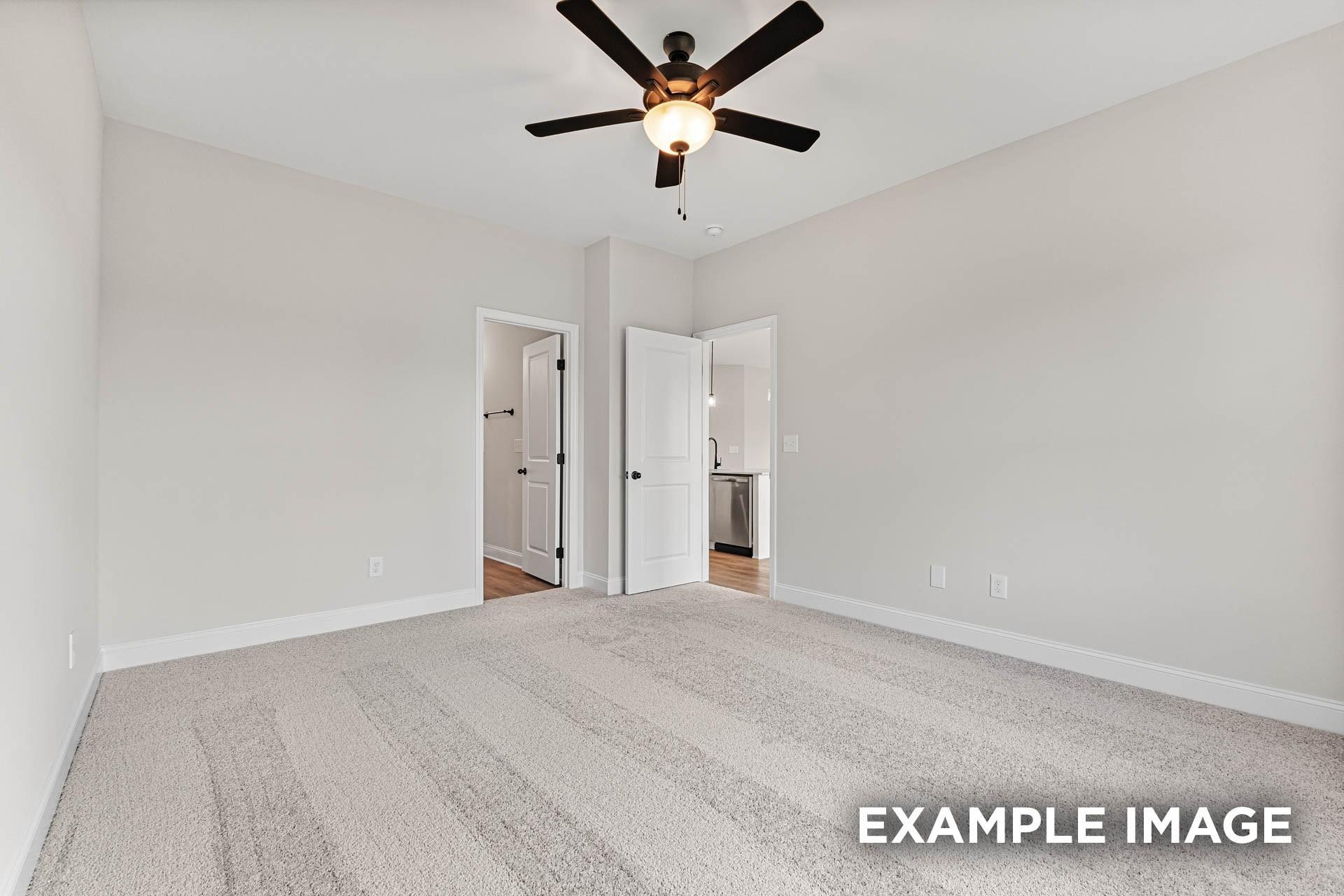 Spacious bedroom with plush carpet and ceiling fan in The Franklin E floor plan at Bailey Park, Fayetteville, Tennessee.