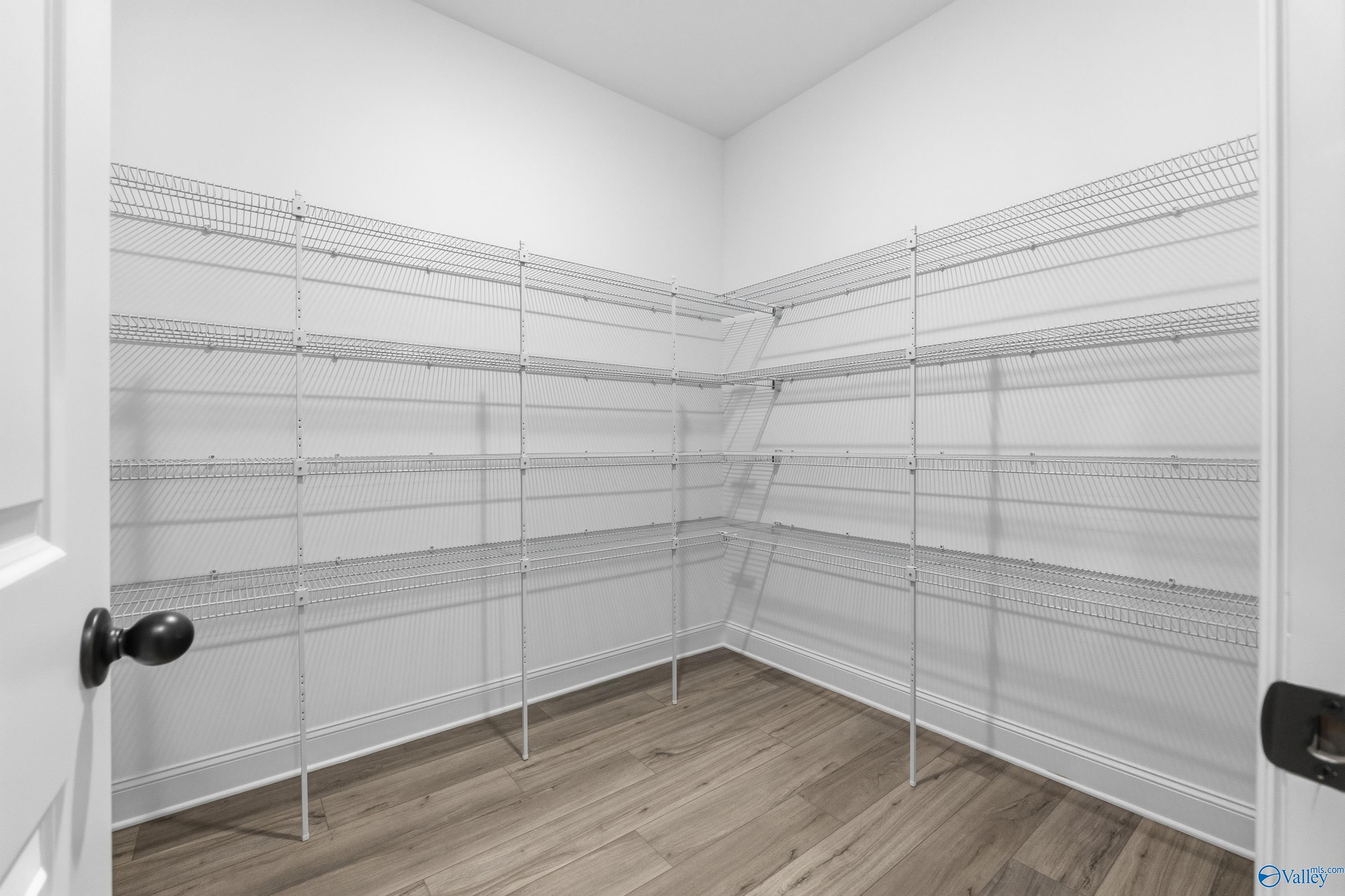 Spacious walk-in pantry with white wire shelving and hardwood floors in The Finleigh by Davidson Homes, Briercreek, Meridianville, Alabama