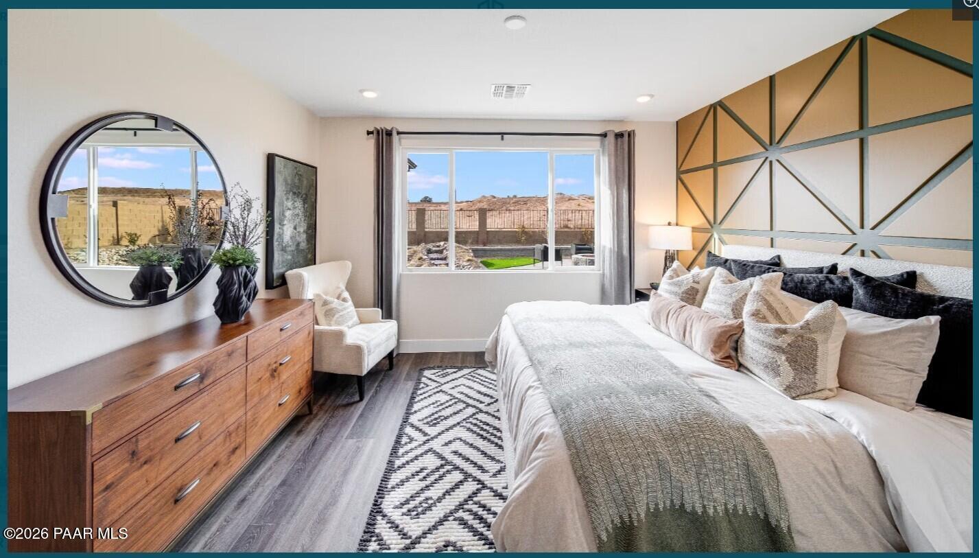 Modern master bedroom with geometric accent wall and backyard view in Boulder II H floor plan, South Ranch, Prescott, AZ.