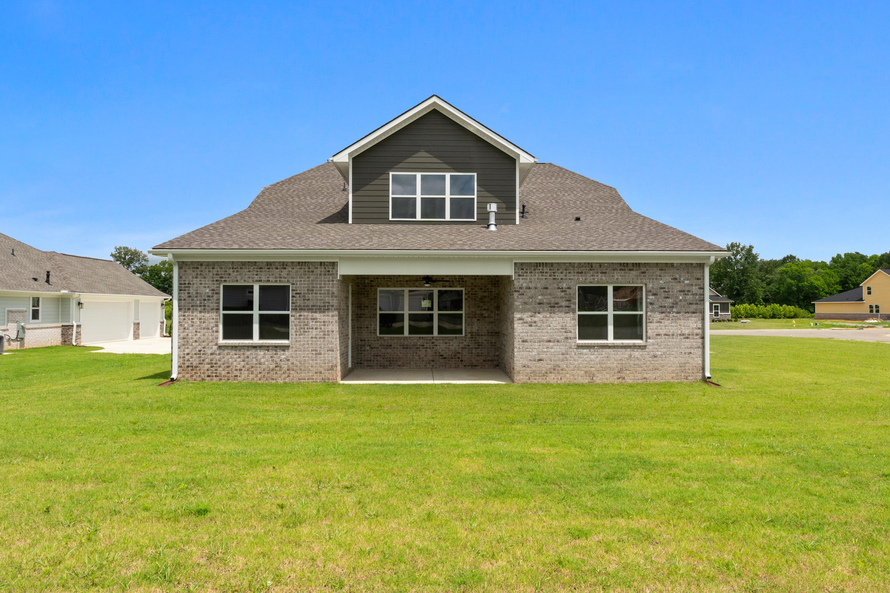 Front elevation of The Oxford A two-story home by Evermore Homes, white siding, gabled roof, covered porch, green lawn in Owens Cross Roads