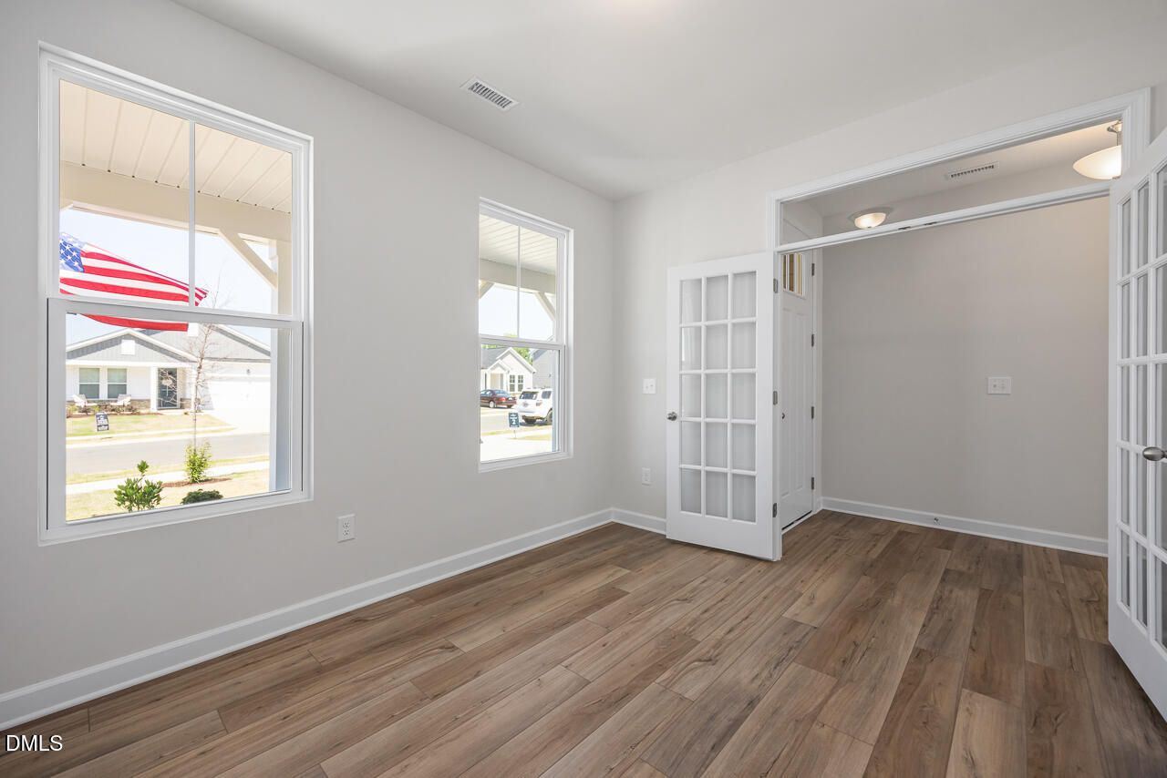Bright home office with French doors and wood-look floors in The Chestnut B plan at Retreat at North Main, Lillington, NC.
