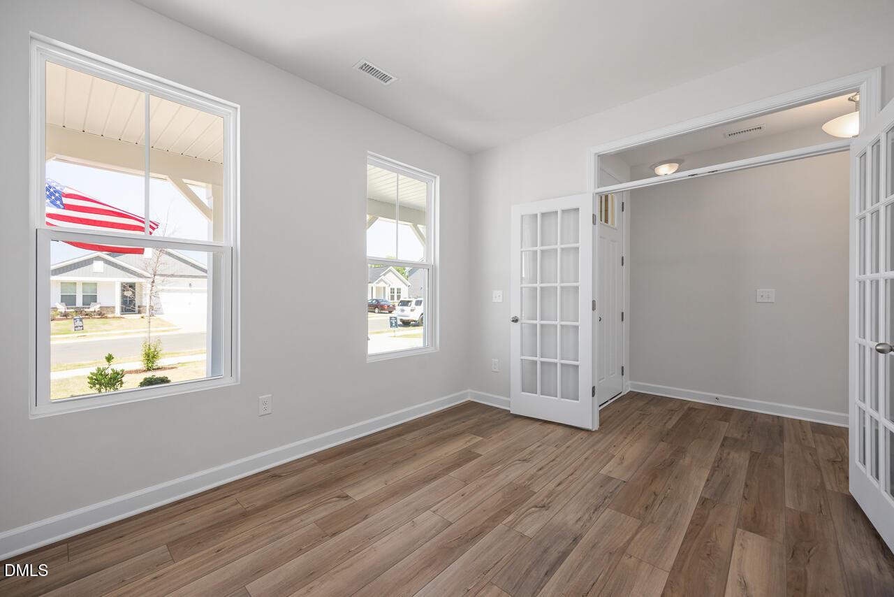 Bright home office with French doors and wood-look floors in The Chestnut B plan at Retreat at North Main, Lillington, NC.
