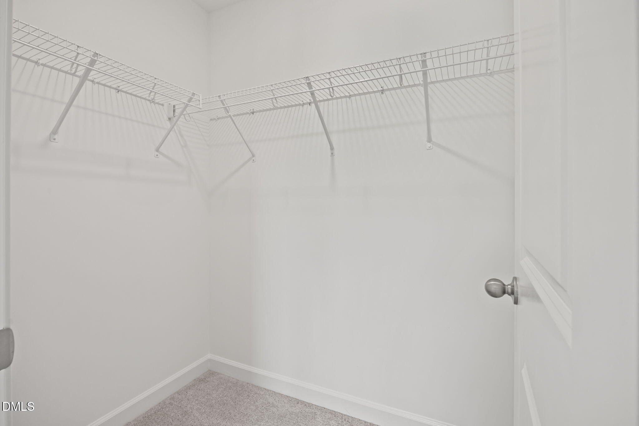Spacious walk-in closet with white wire shelving and hanging rods in The Willow D 4-bedroom home, Wendell Ridge, NC
