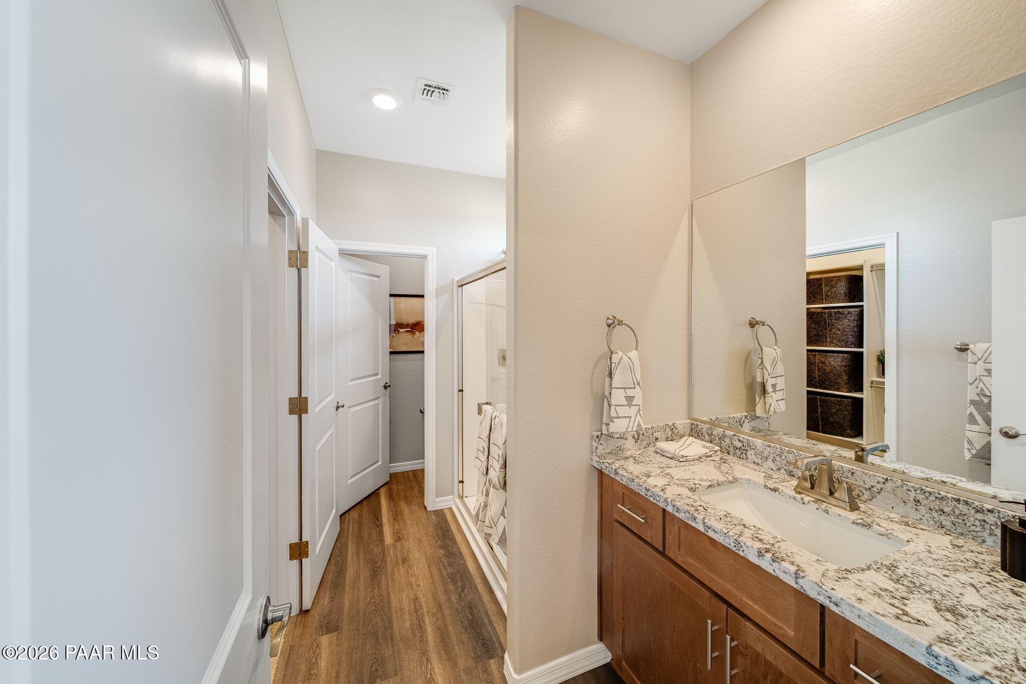 Modern bathroom with granite vanity and walk-in shower in The Savannah C floor plan at South Ranch, Prescott, Arizona.