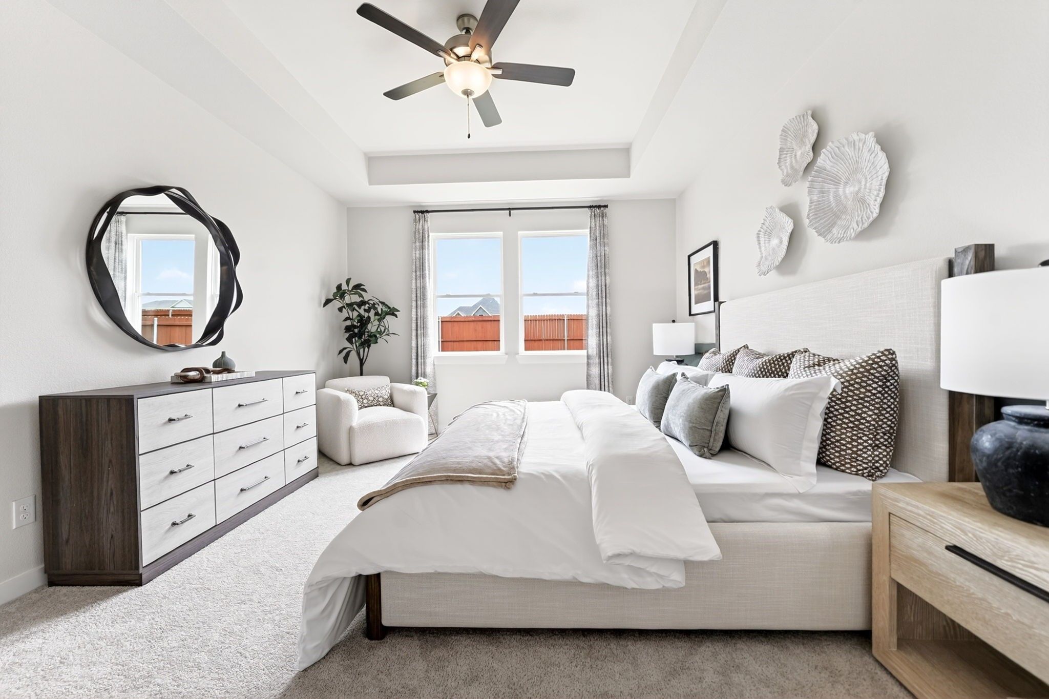 Bright primary bedroom with tray ceiling in The Laurel I floor plan by Davidson Homes in Heartland, Texas.