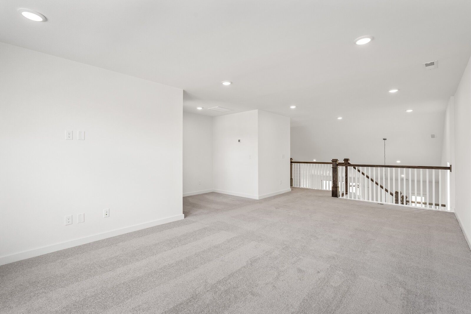 Spacious carpeted loft area with recessed lighting in The Ridgeport C floor plan at Woods Crossing, Gallatin, Tennessee.