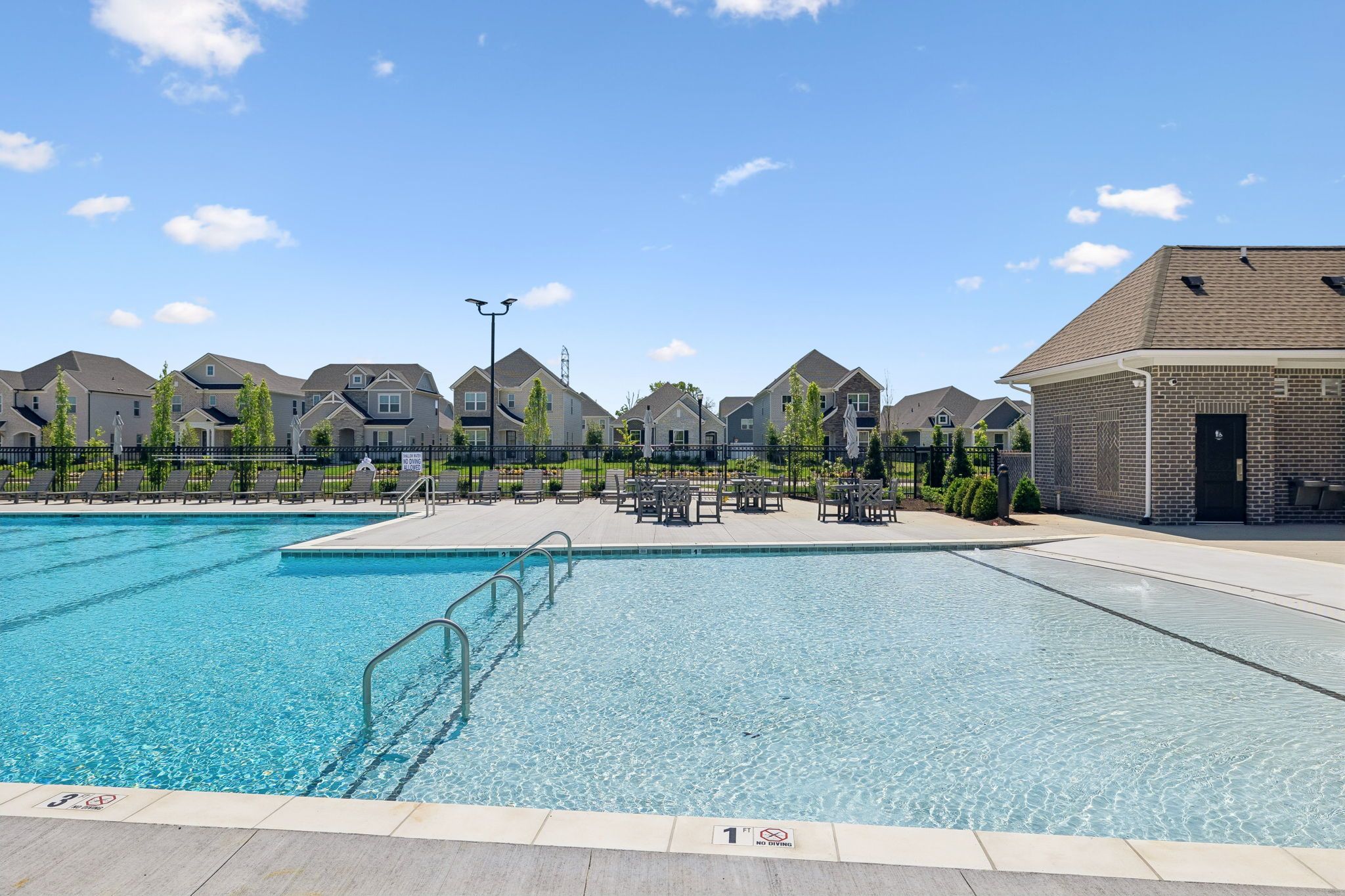 Community swimming pool at Bradshaw Farms in Mt. Juliet, TN with lounge seating and clubhouse, built by Davidson Homes.