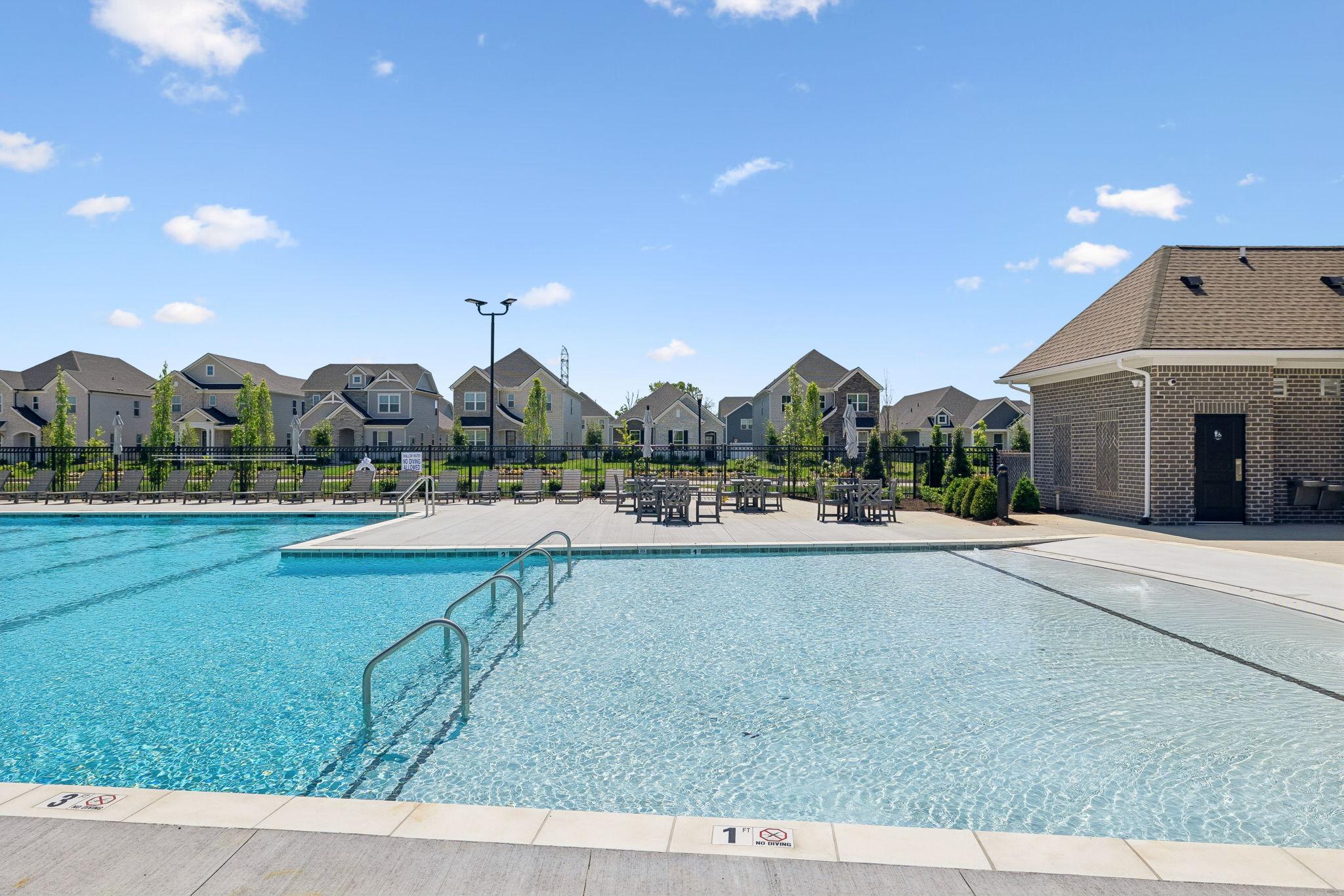 Community swimming pool at Bradshaw Farms in Mt. Juliet, TN with lounge seating and clubhouse, built by Davidson Homes.