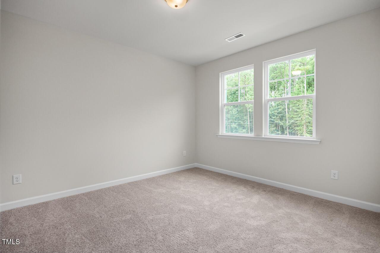Bright bedroom with large double windows, neutral walls, and beige carpet in Davidson Homes The Aspen B, Wake Forest, NC