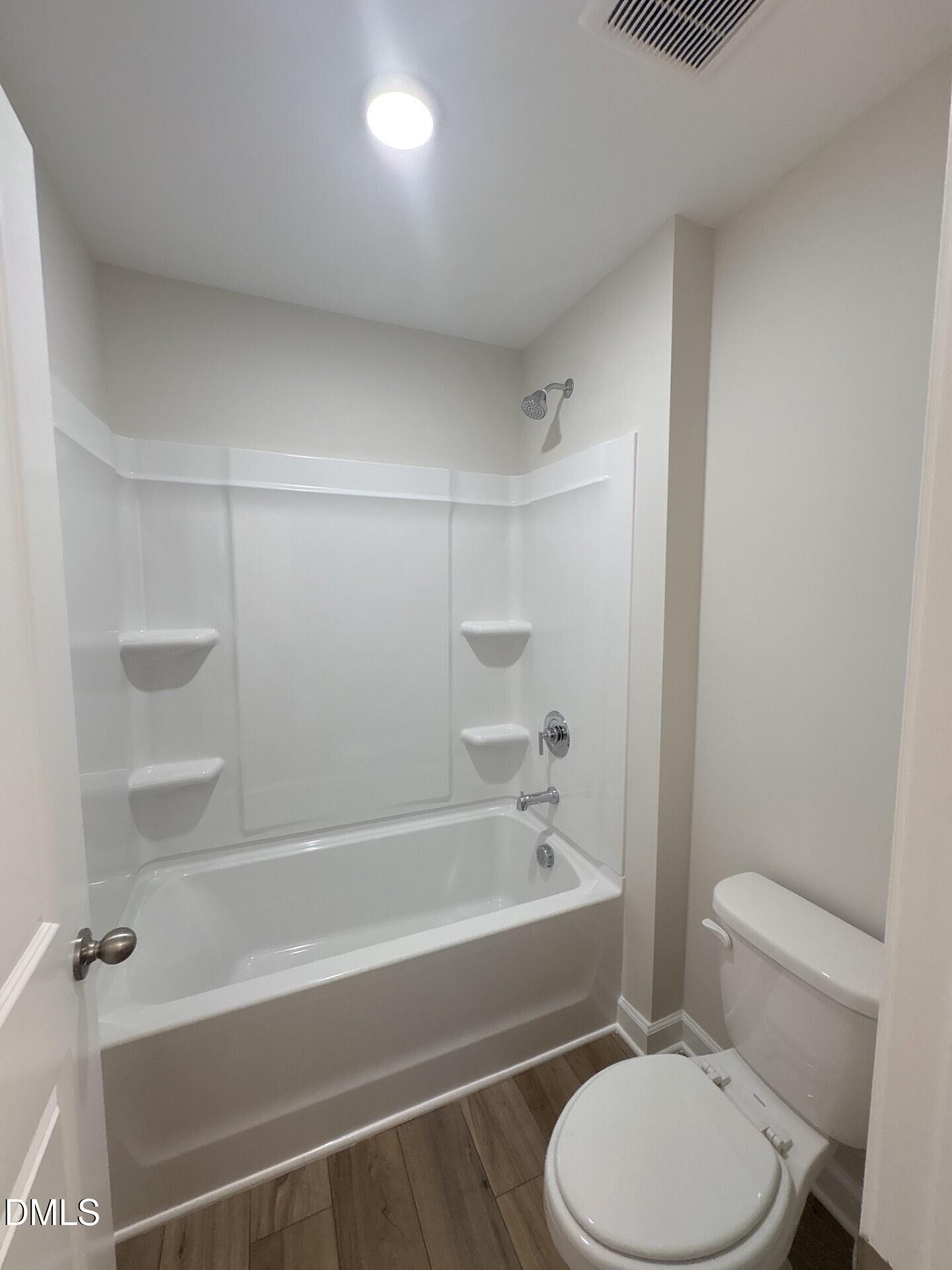 Full bathroom with white tub-shower combo and modern fixtures in The Ash C floor plan at Woodland Crossing, Zebulon, NC.