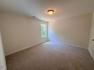 Spacious, carpeted bedroom with neutral walls in The Willow B floor plan at Woodland Crossing, Zebulon, North Carolina.
