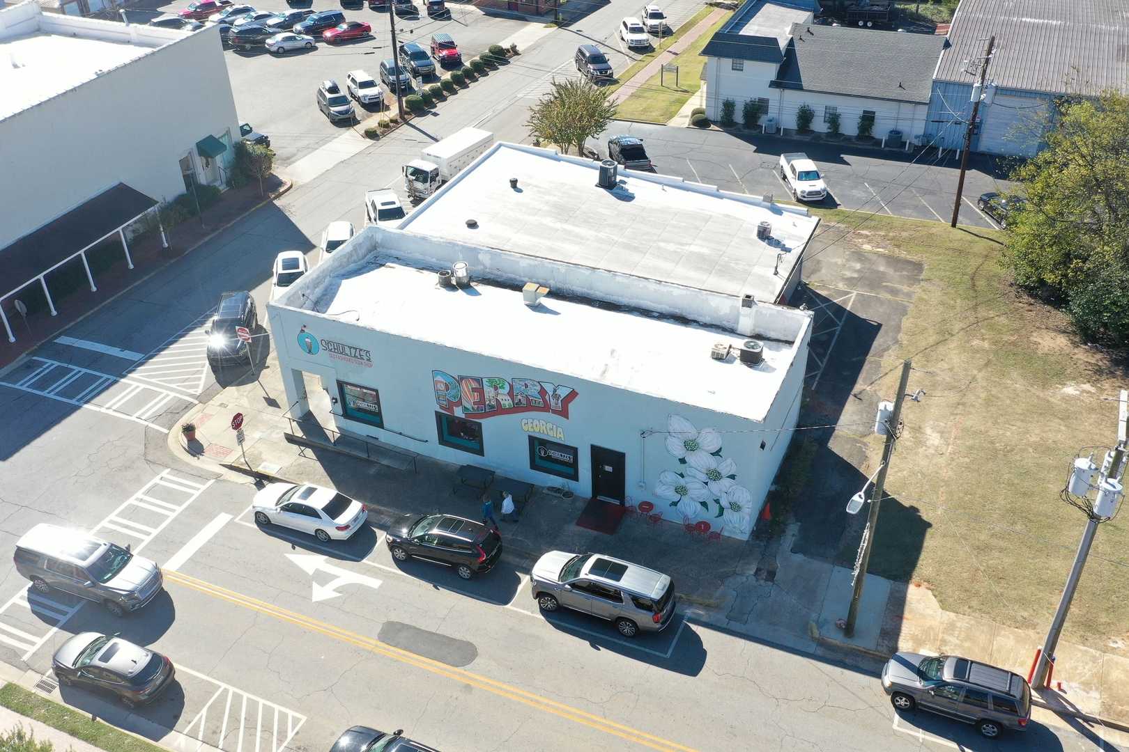 Aerial view of Dairy Queen ice cream shop in Perry Georgia near Ivy Glen with white building, parked cars, and busy street intersection