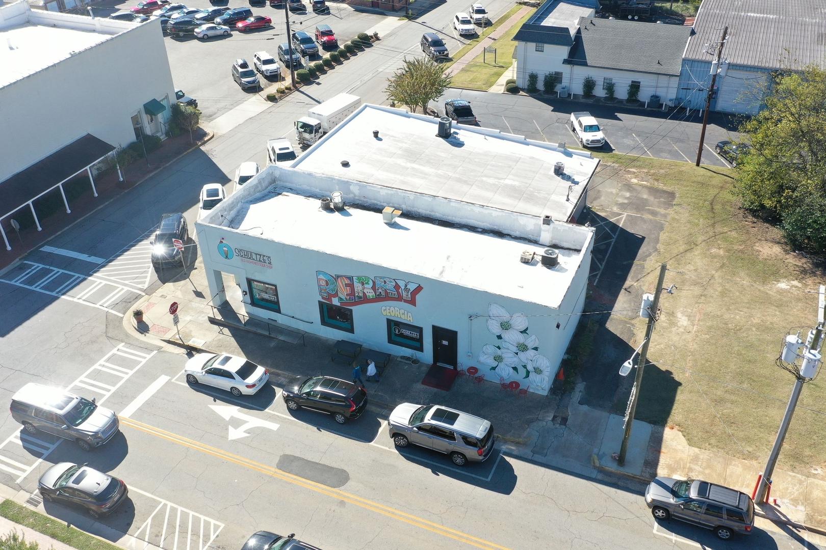 Aerial view of Dairy Queen ice cream shop in Perry Georgia near Ivy Glen with white building, parked cars, and busy street intersection