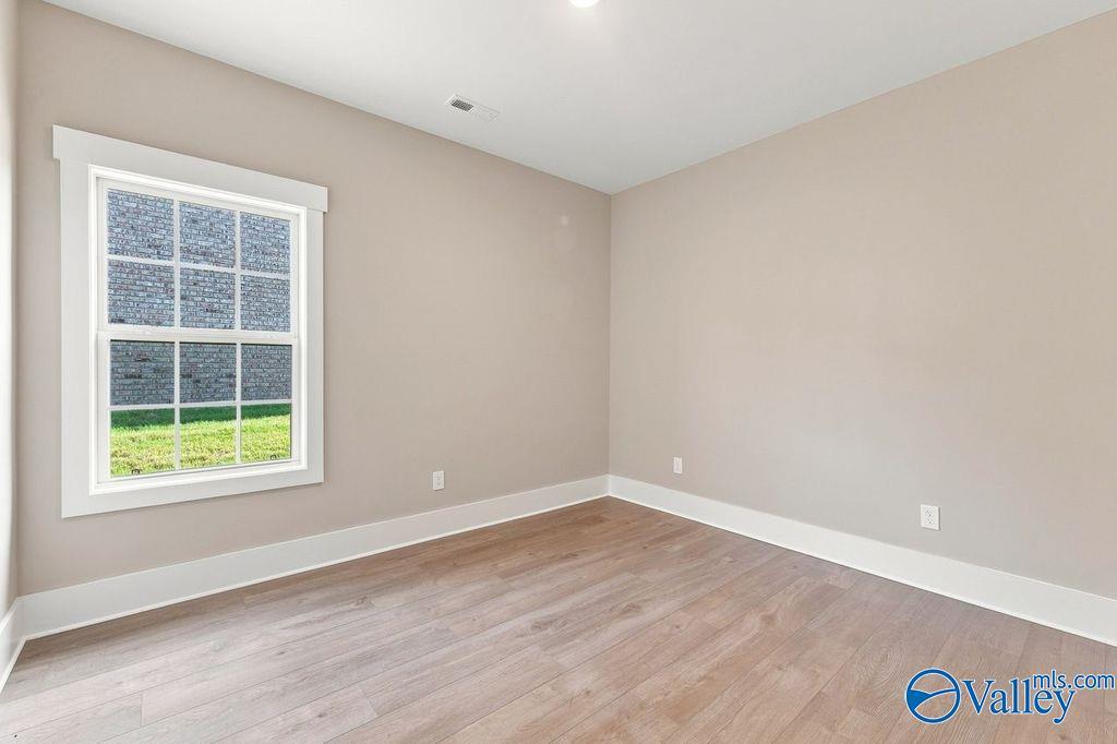 Bright, neutral-toned bedroom with wood-look flooring in The Rockford floor plan at Cain Park, Hartselle, Alabama.
