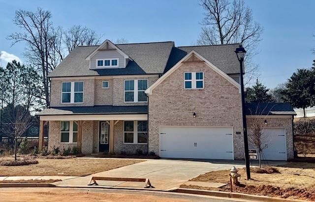 Two-story brick home with 3-car garage, covered porch, and landscaped yard in Melody Lakeside Estates, Buford, Georgia
