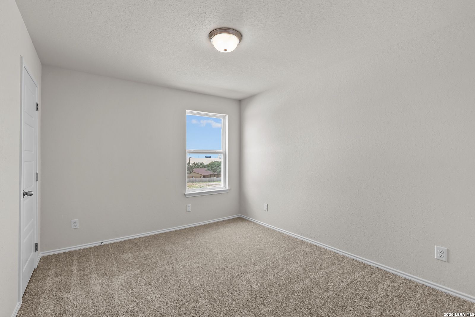 Bright secondary bedroom with neutral walls and plush carpet in The Gillian B floor plan at Meadows at Oak Creek, San Antonio.