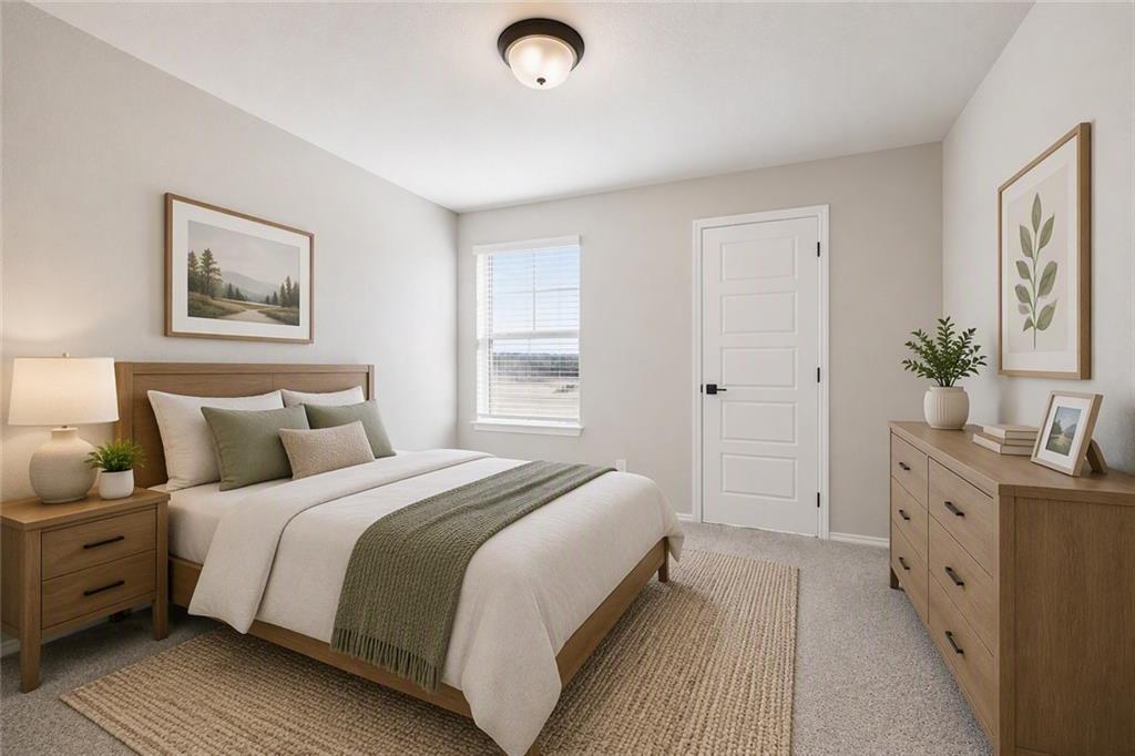Serene primary bedroom with wood bed frame, sage green accents, and natural light in Davidson Homes Charlotte B plan, Cartersville GA