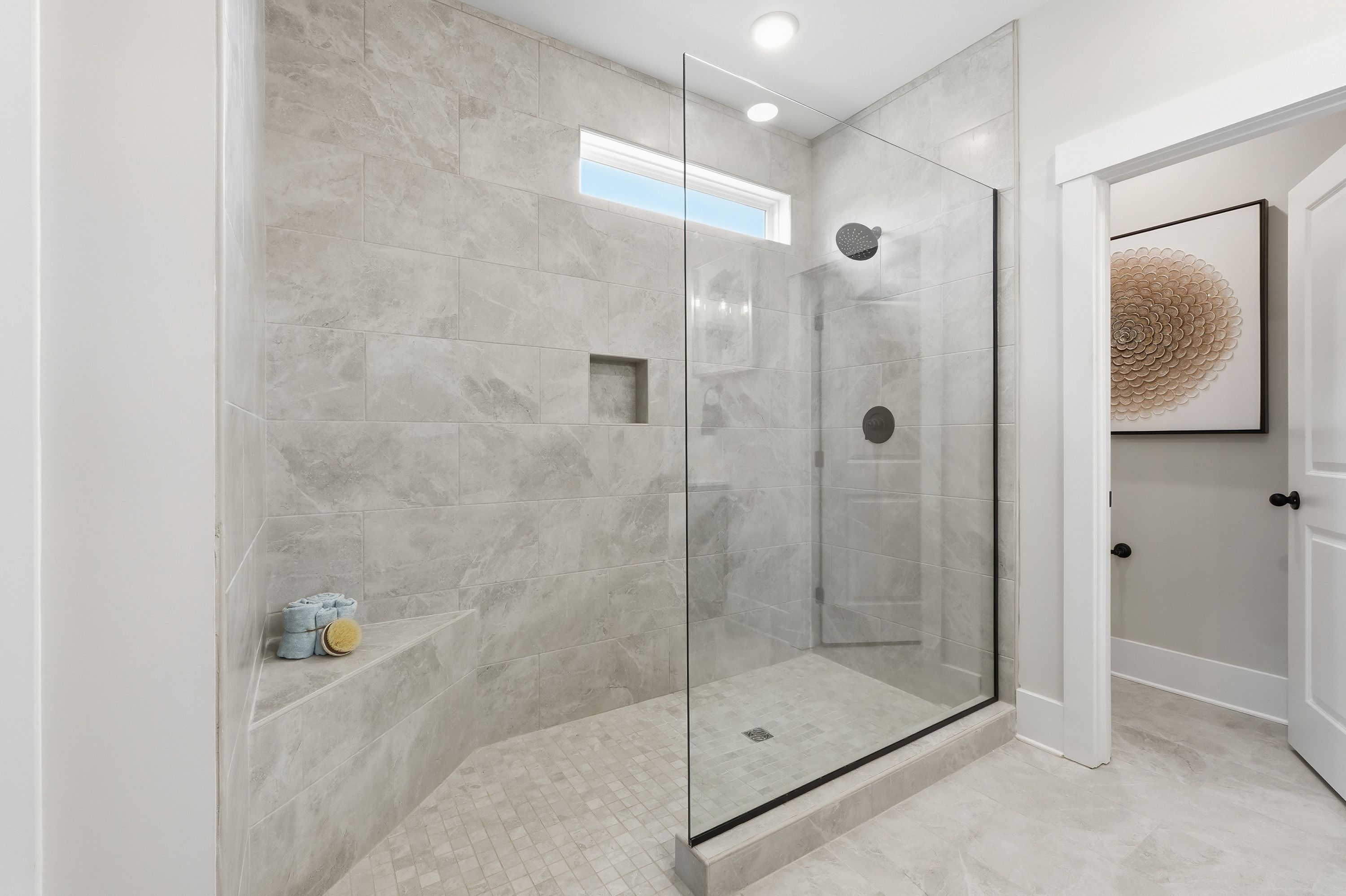 Spacious walk-in shower in Noble Ridge home, Cullman AL by Davidson Homes featuring gray tile walls and glass enclosure