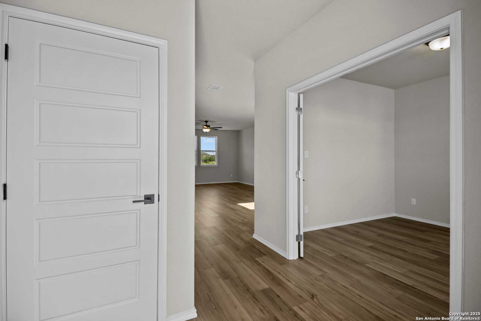 Spacious home study with wood floors, ceiling fan, and window in The Murray F by Davidson Homes, Converse, Texas