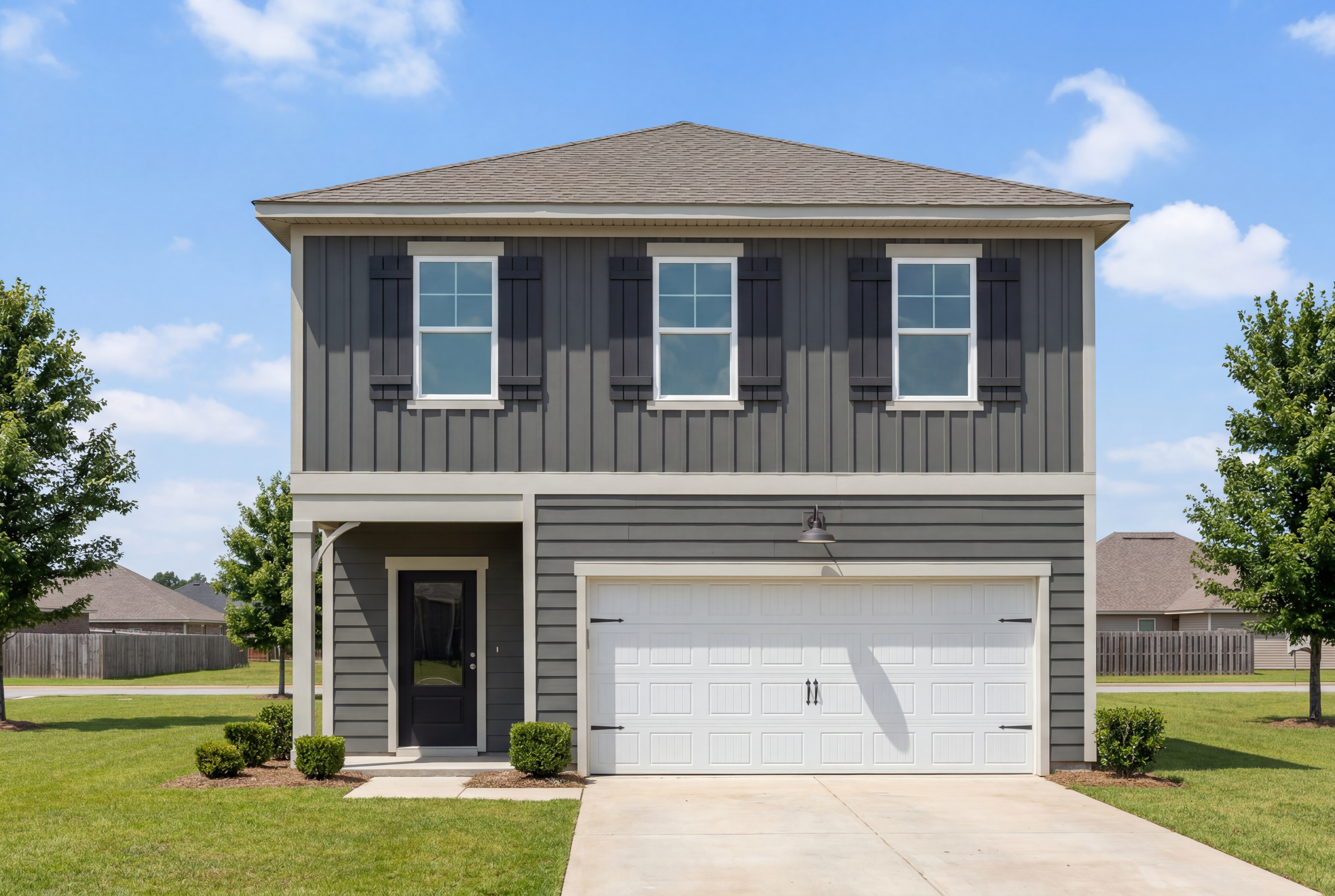 Two-story exterior of The Burton B home design in Cullman, Alabama featuring dark gray siding and a two-car garage.