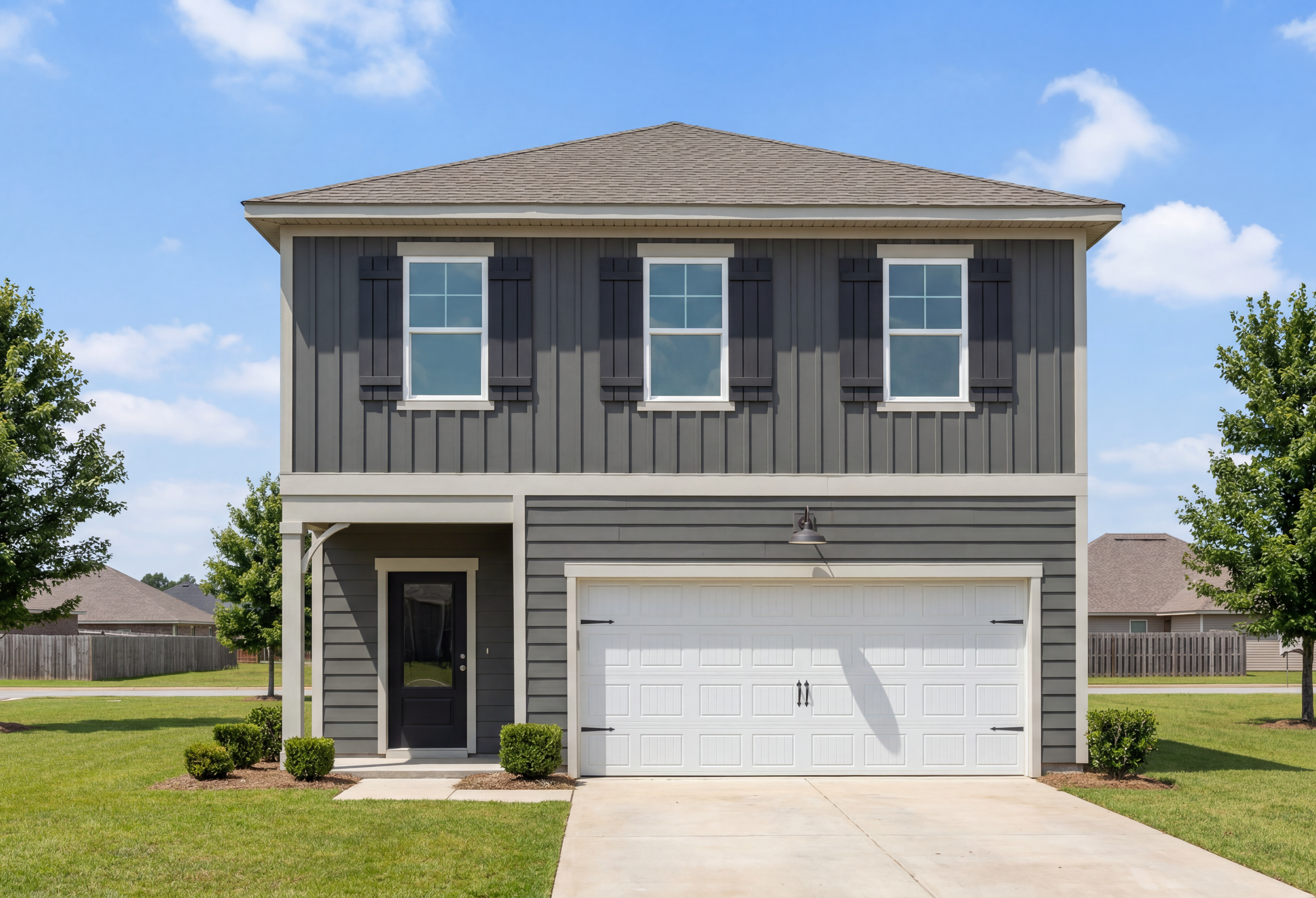 Two-story exterior of The Burton B home design in Cullman, Alabama featuring dark gray siding and a two-car garage.