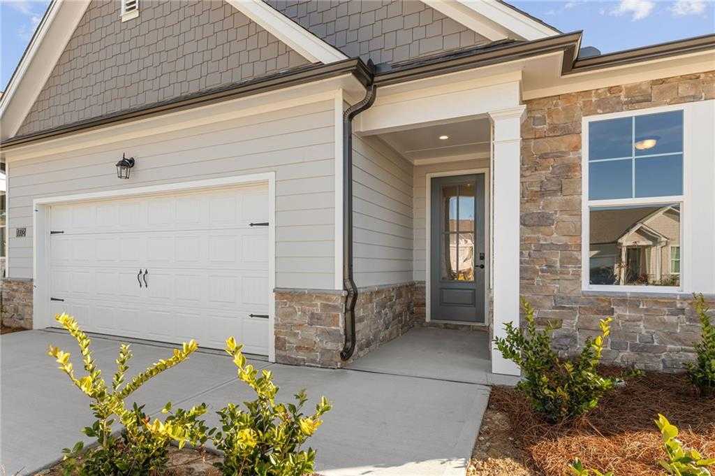 Front exterior of Davidson Homes The Glenwood A: single-story with 2-car garage, gray siding, stone accents, covered entry in Kelly Preserve, Loganville, GA