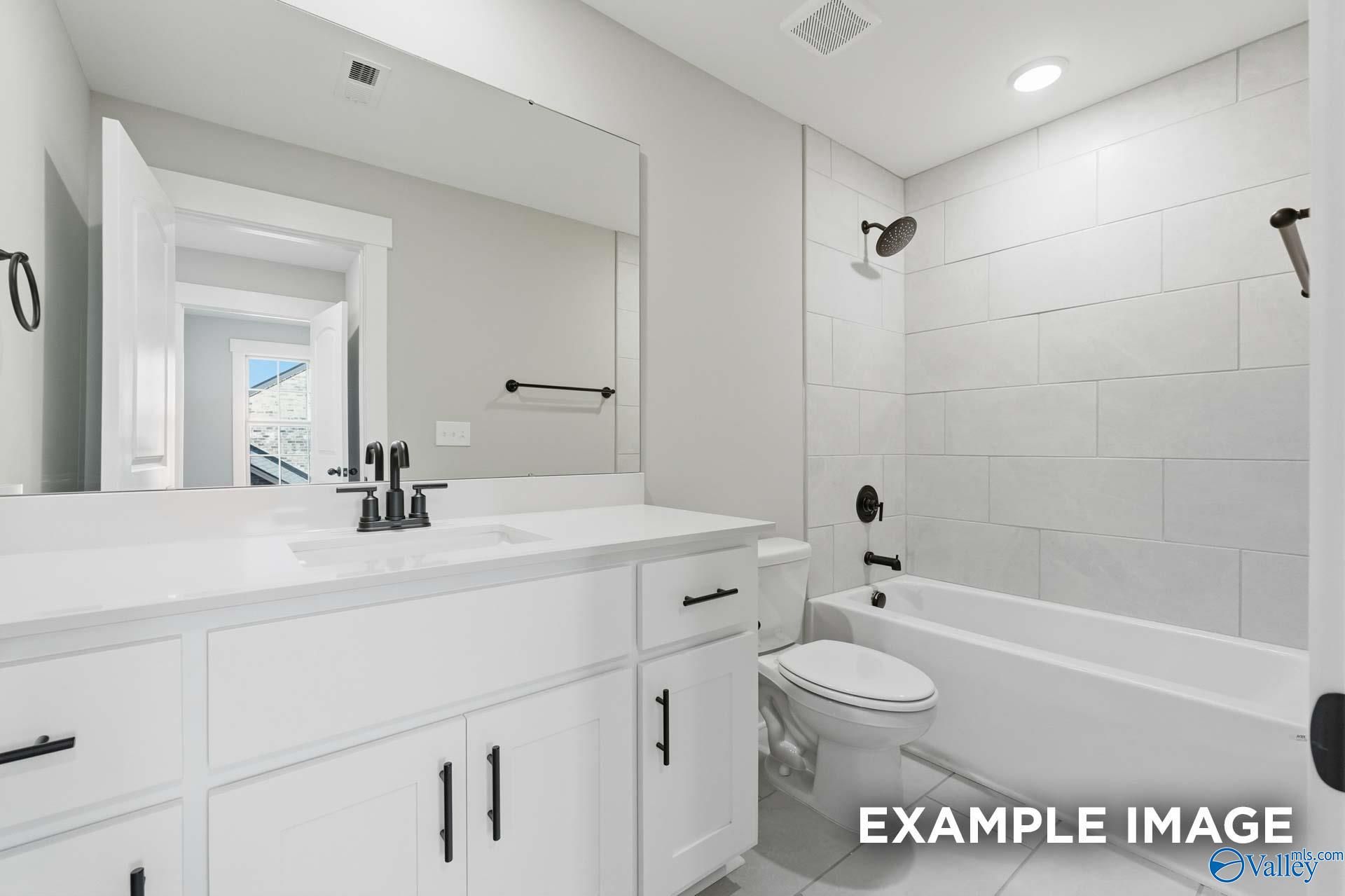 Modern master bathroom with white subway tiles, double vanity, freestanding tub, and walk-in shower in Davidson Homes The Emory, Decatur, Alabama