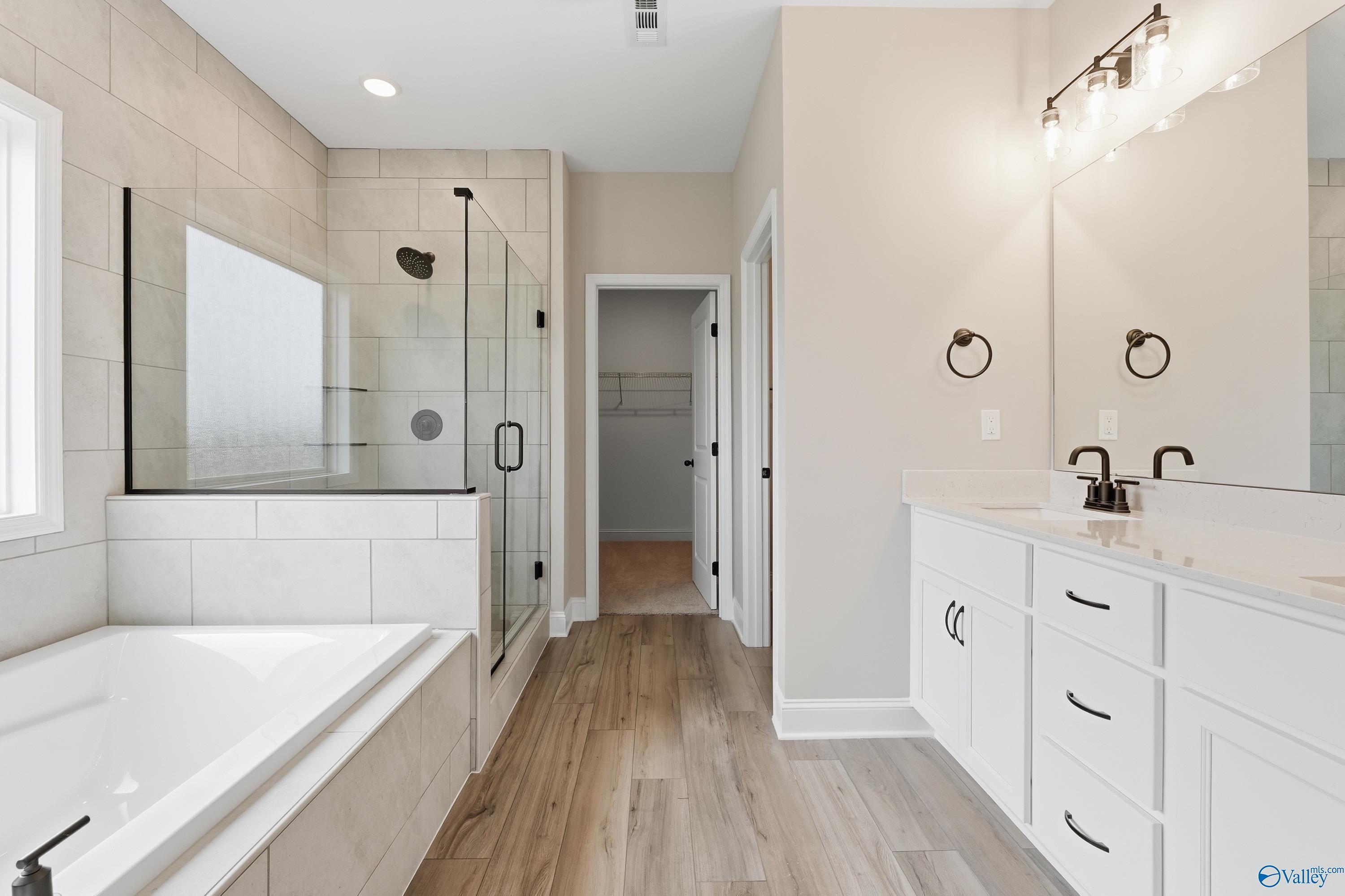 Elegant master bathroom with glass shower, freestanding tub, double vanity in Davidson Homes The Rockford C, Athens Alabama