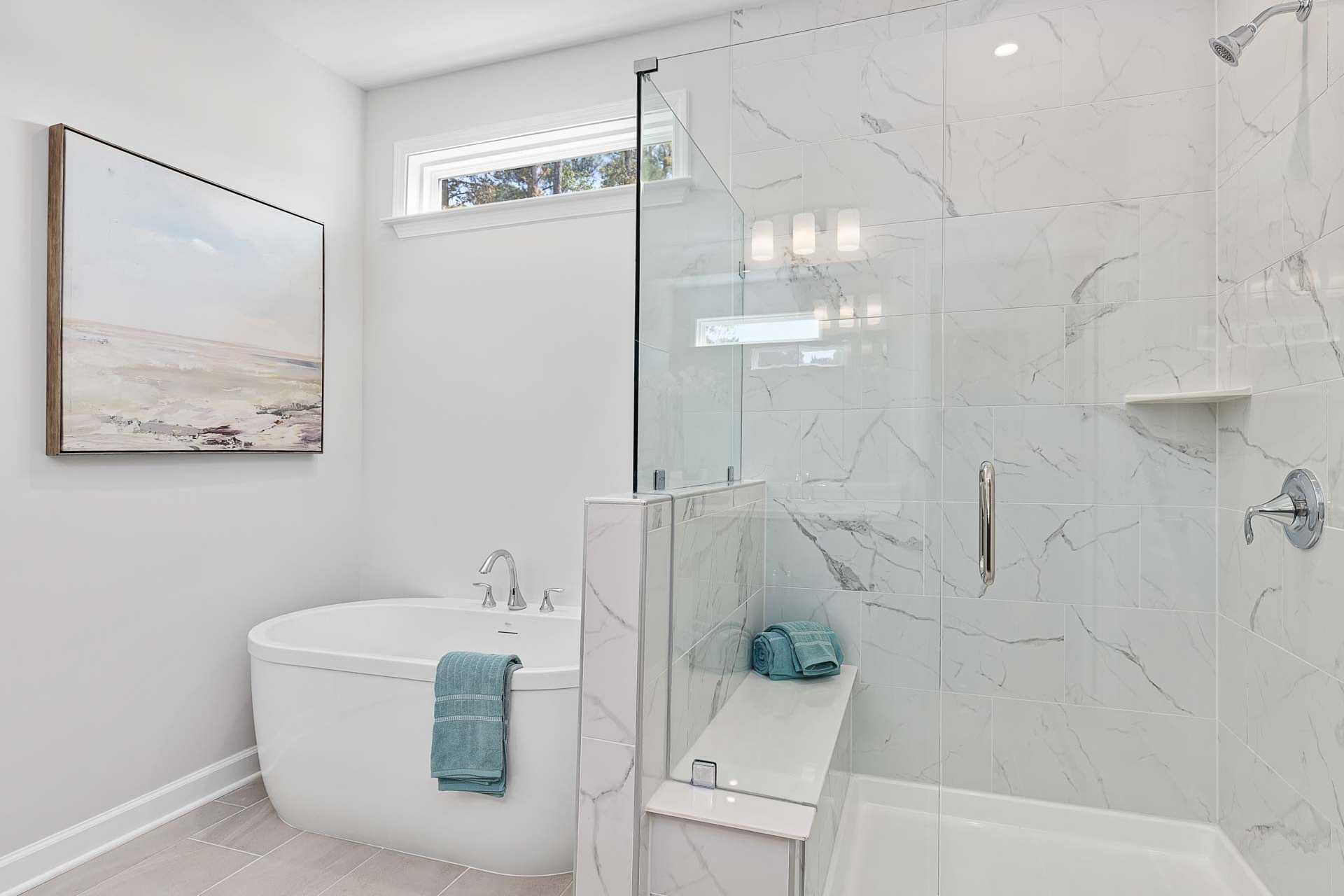 Luxury spa bathroom in Glenmere Knightdale NC by Davidson Homes with freestanding tub, glass shower, and marble tiles