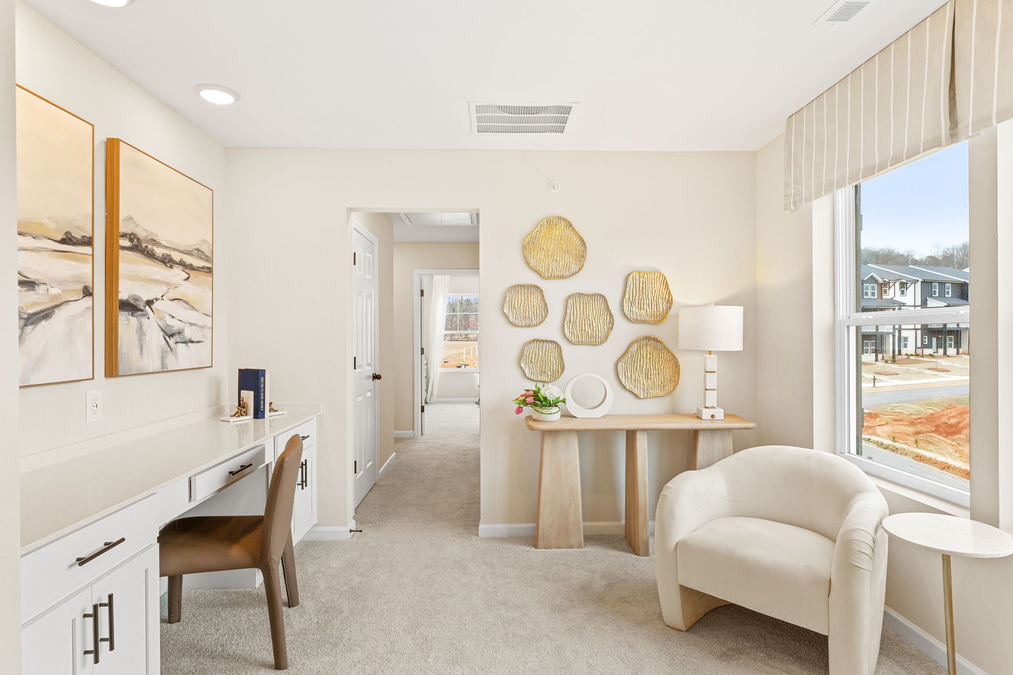 Spacious home office in Hemingway Cumming GA with wooden desk, abstract wall art, woven decor, and neighborhood view