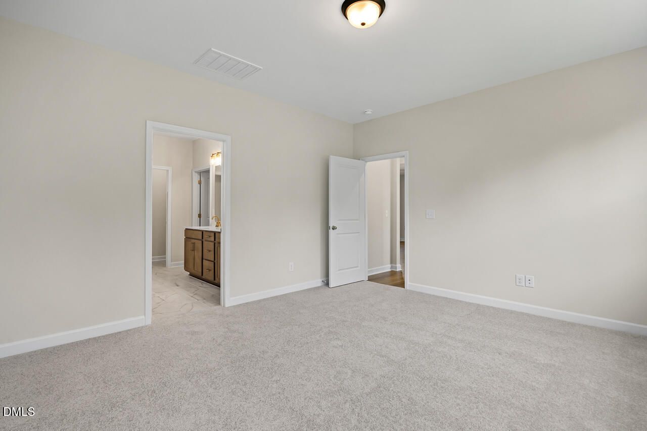 Spacious carpeted bedroom with ensuite bath access in Davidson Homes The Birch II C plan, Sage on North Main, Wake Forest, NC