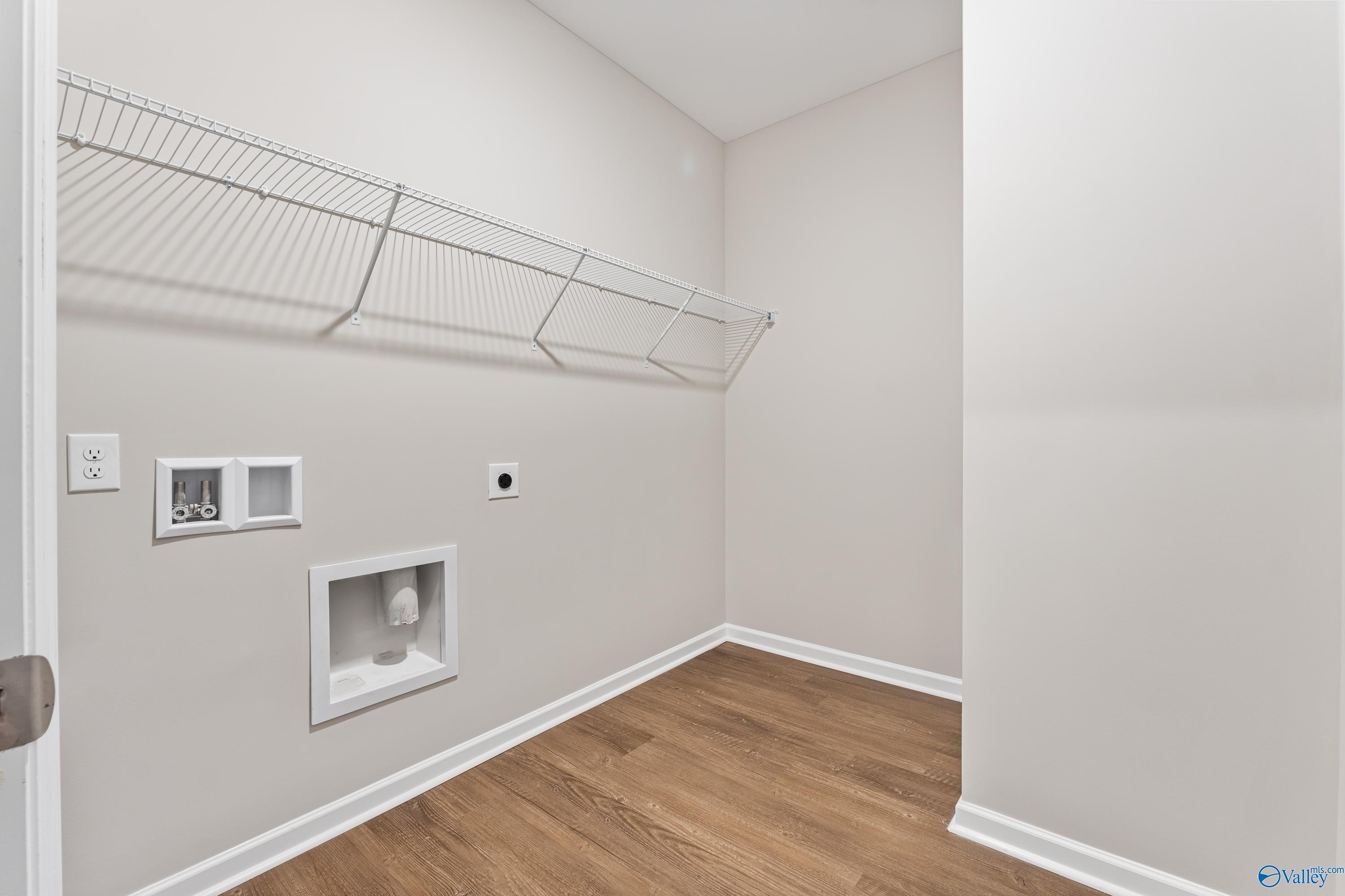 Spacious laundry room with wire shelving, utility sink, and washer-dryer hookups in Davidson Homes The Phoenix, Fayetteville, TN