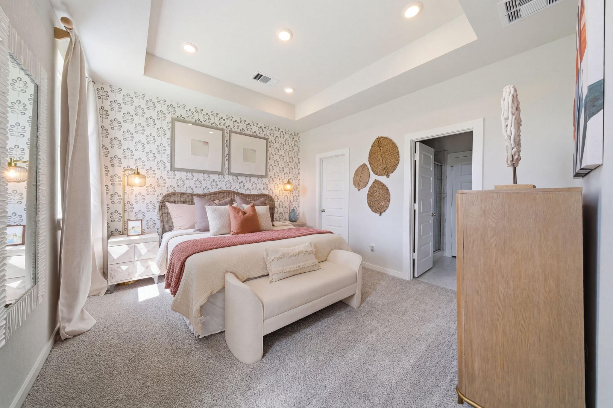 Elegant master bedroom at Spring Branch Crossing in Conroe Texas with king bed, woven wall decor, and neutral tones
