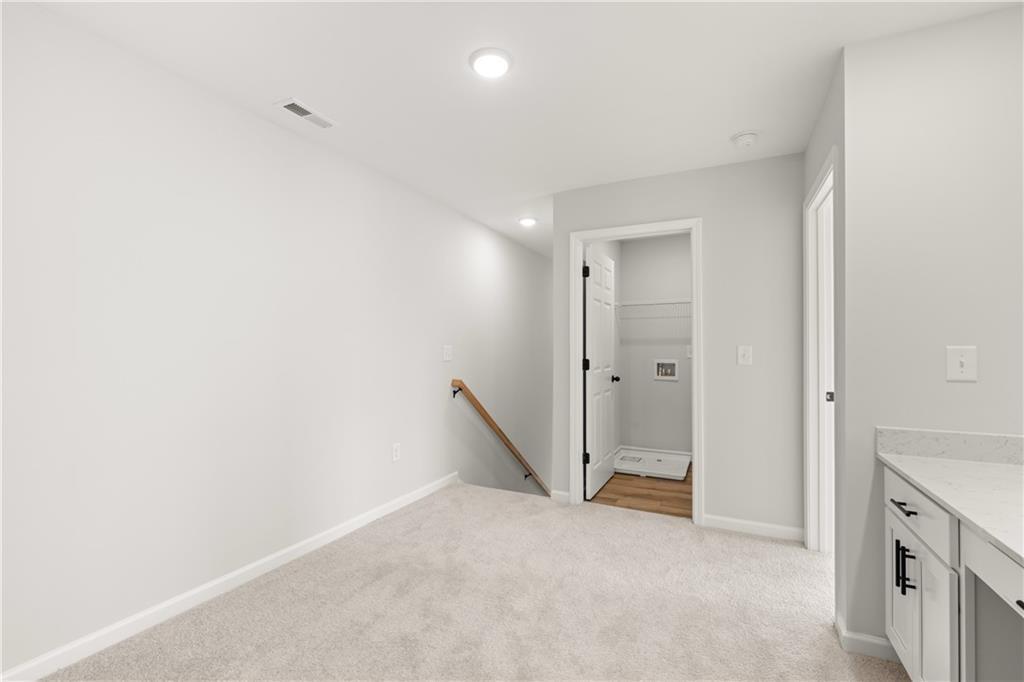 Upper-level laundry room and hallway in The Durham D floor plan by Davidson Homes in Hemingway, Cumming, Georgia.
