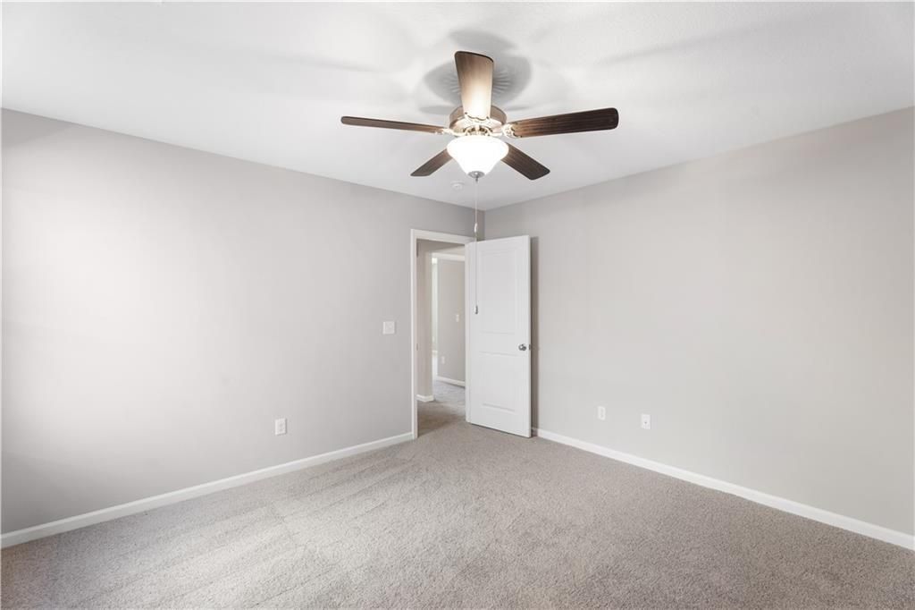 Bright bedroom with ceiling fan and plush carpet in The Washington floor plan at Summer Vineyard, Phenix City, Alabama.