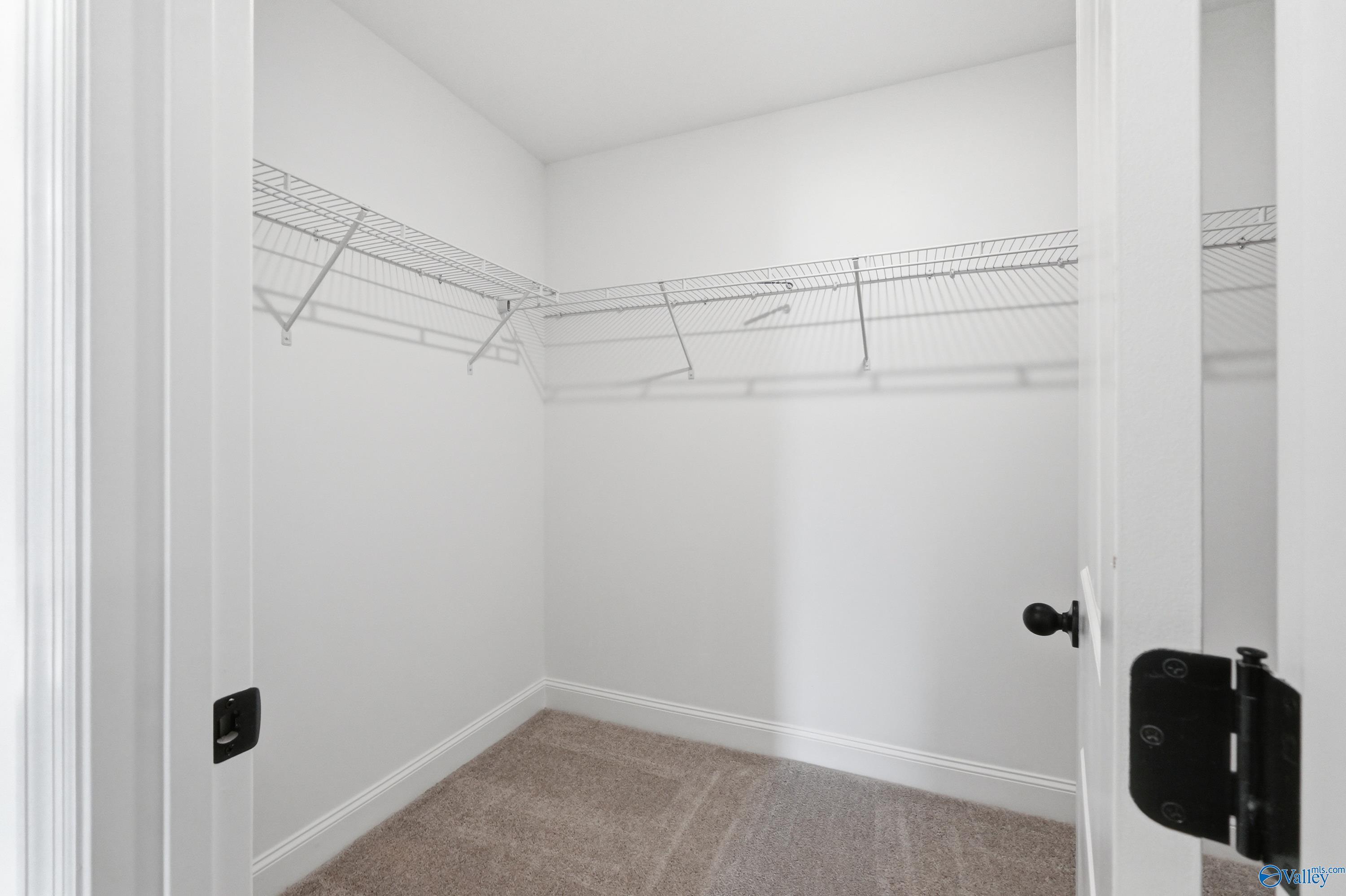 Walk-in bedroom closet with wire shelving in The Franklin floor plan at Heritage Lakes, New Market, Alabama.
