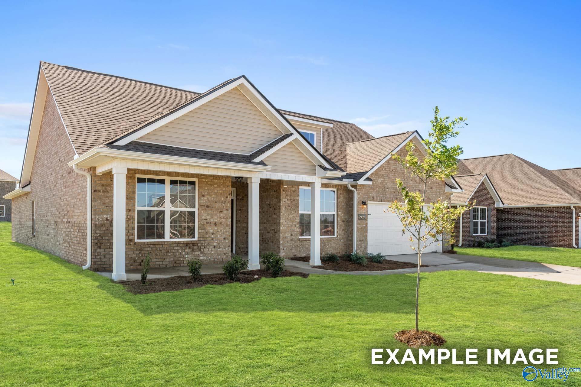 Single-story brick home with columned front porch, two-car garage, and lush lawn in Cain Park, Hartselle, Alabama - Davidson Homes The Harrison
