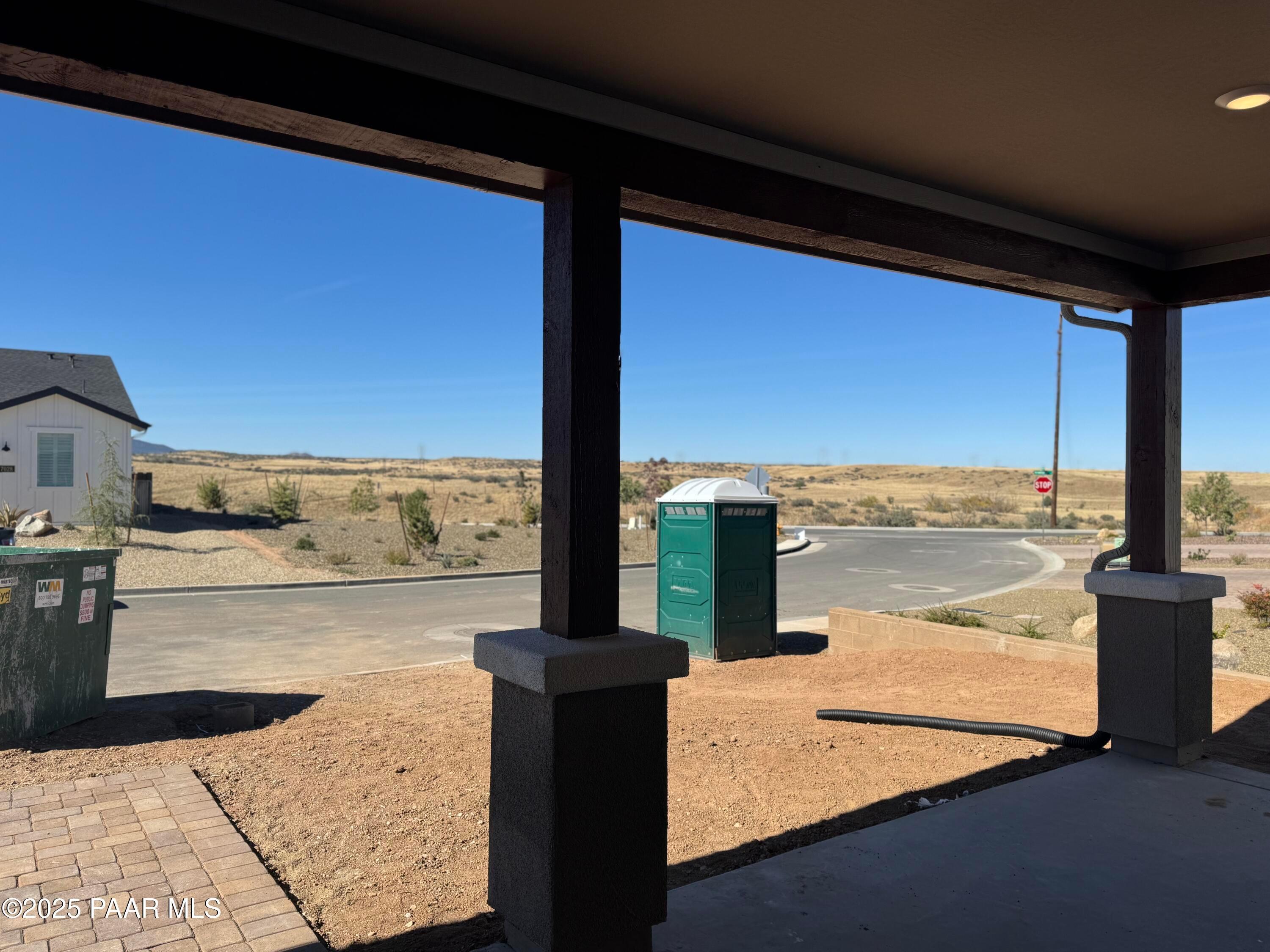 Covered patio with sturdy beam posts overlooking desert landscape and construction site in Westwood, Prescott, Arizona Davidson Homes Sunrise II A