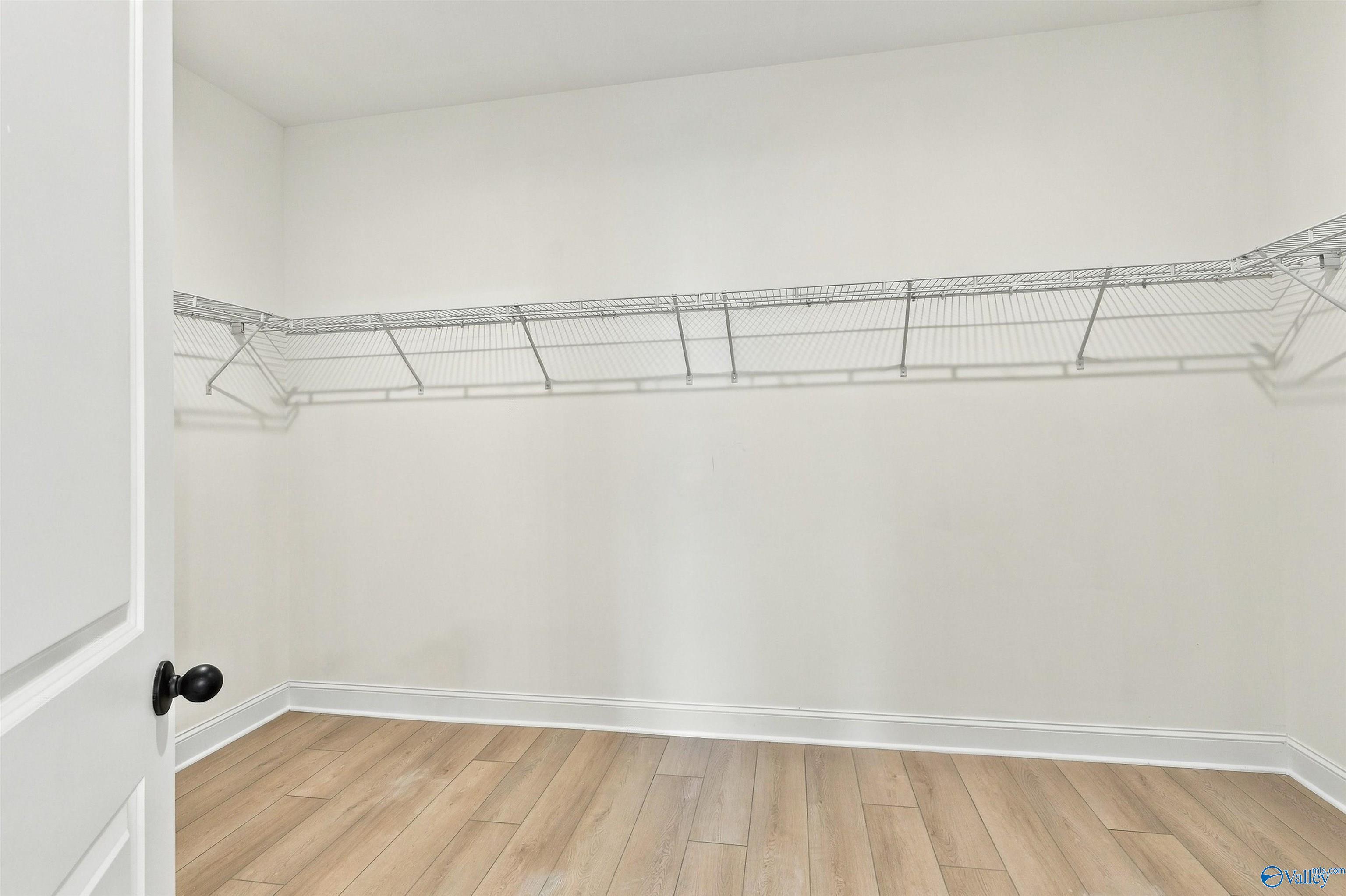 Spacious walk-in closet with wire shelving and wood-look flooring in Davidson Homes' Valencia plan at Riverton Preserve, Huntsville