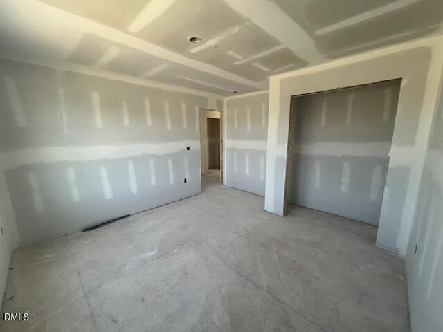 Unfinished bedroom with drywall and walk-in closet in The Ash C floor plan by Davidson Homes in Lillington, North Carolina