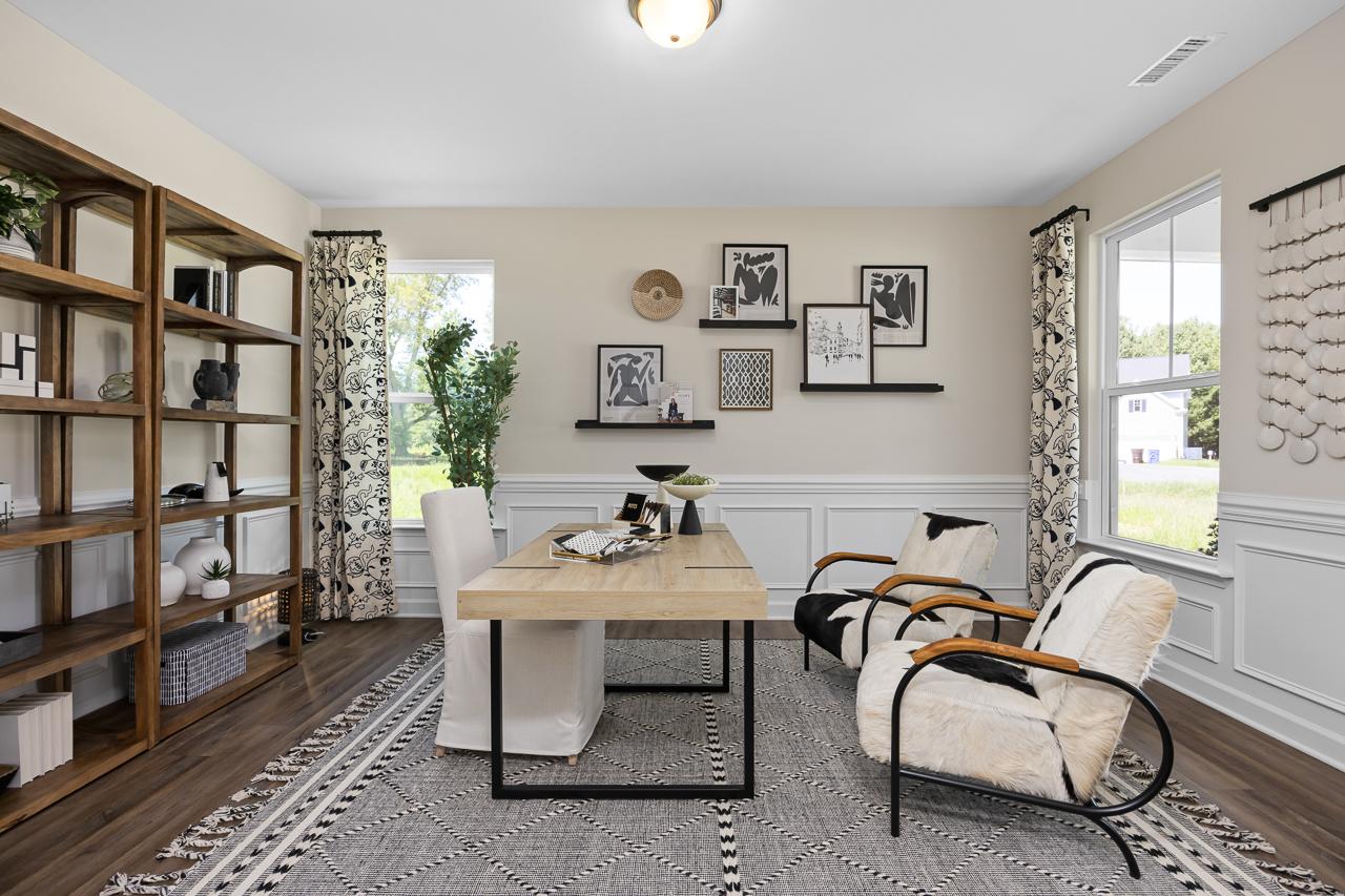 Cozy home office at Wellers Knoll in Lillington NC with wooden bookshelves, large desk, leather chairs, and woven decor