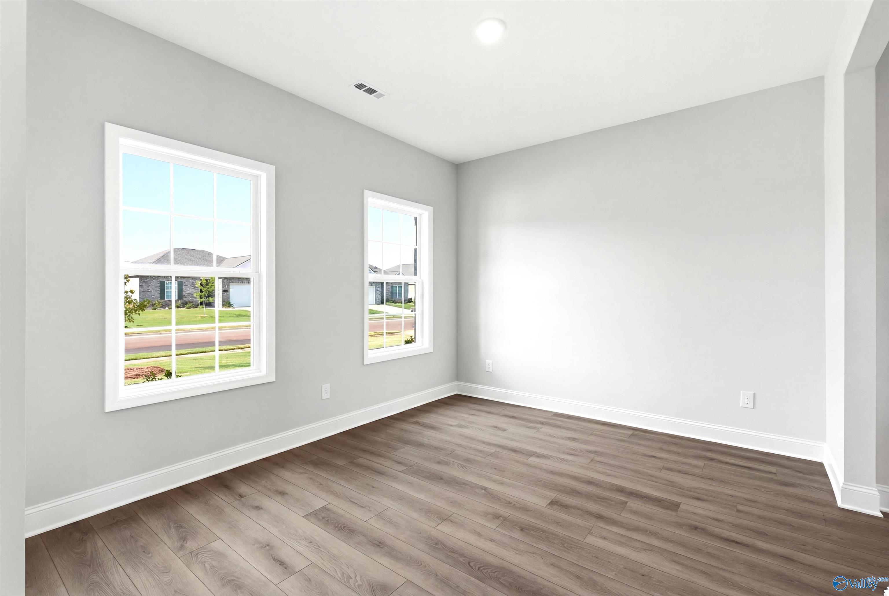 Bright, neutral-toned bedroom with luxury vinyl plank flooring in The Shelby A floor plan at Clearview, Hazel Green, AL.