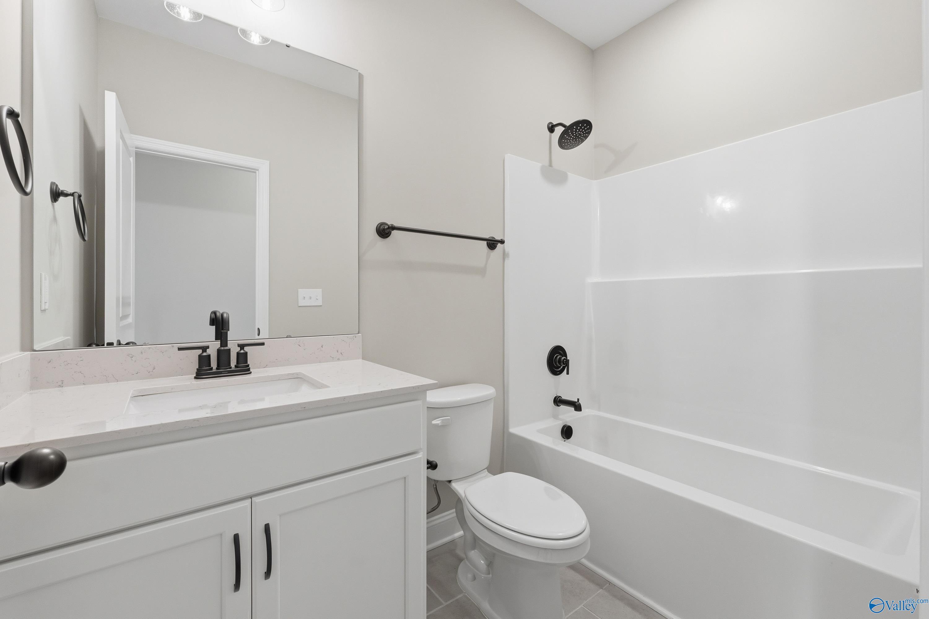 Modern guest bathroom featuring tub-shower combo, white vanity, and subway tile surround in Davidson Homes The Rockford, Harvest, AL