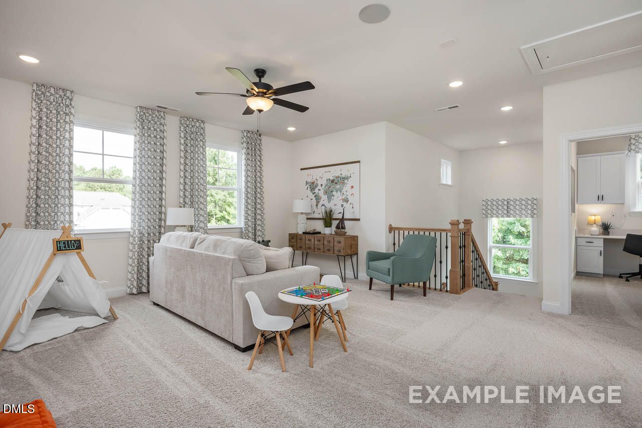 Cozy upstairs loft with gray sectional sofa, kids' teepee play area, and staircase in 4-bedroom Davidson Homes Crawford D, Angier NC