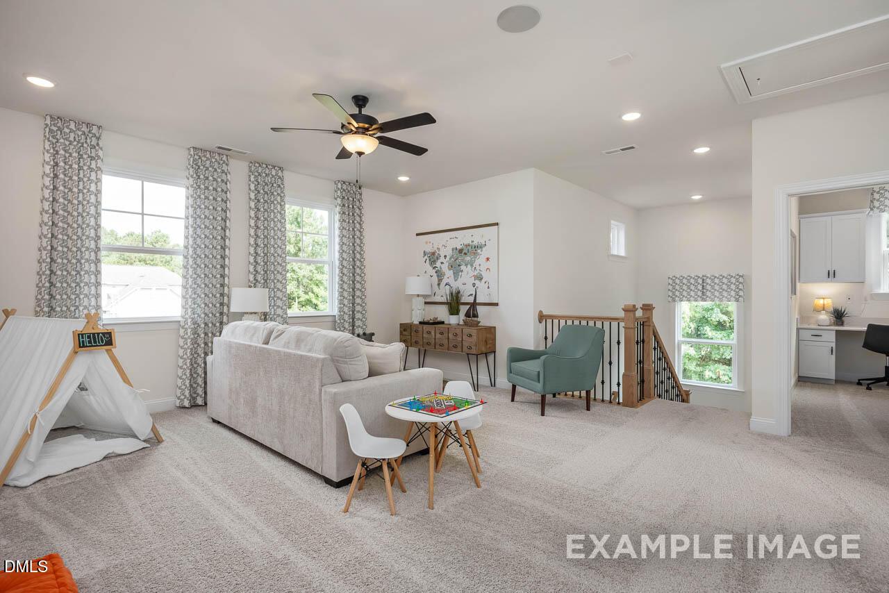 Cozy upstairs loft with gray sectional sofa, kids' teepee play area, and staircase in 4-bedroom Davidson Homes Crawford D, Angier NC