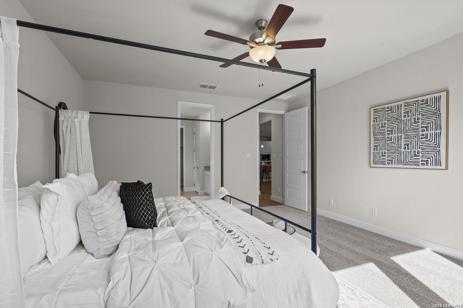 Spacious primary bedroom with canopy bed in The Lanier H floor plan at Ladera, San Antonio, Texas by Davidson Homes.