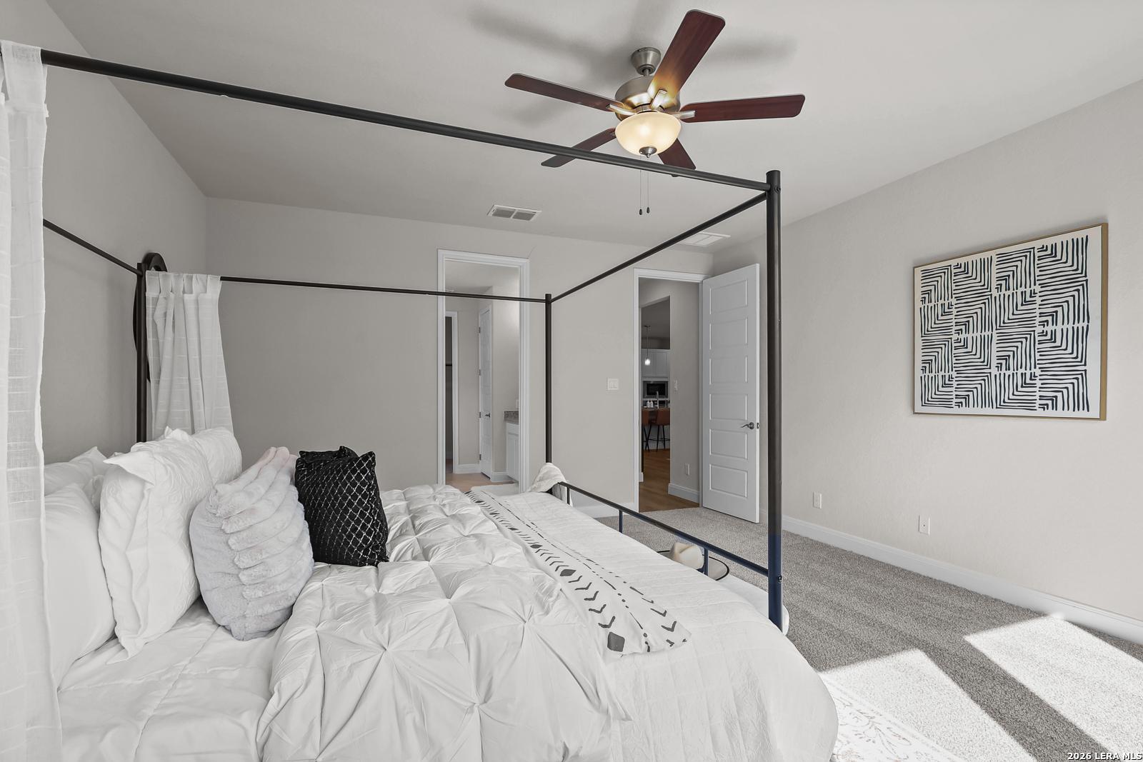 Spacious primary bedroom with canopy bed in The Lanier H floor plan at Ladera, San Antonio, Texas by Davidson Homes.