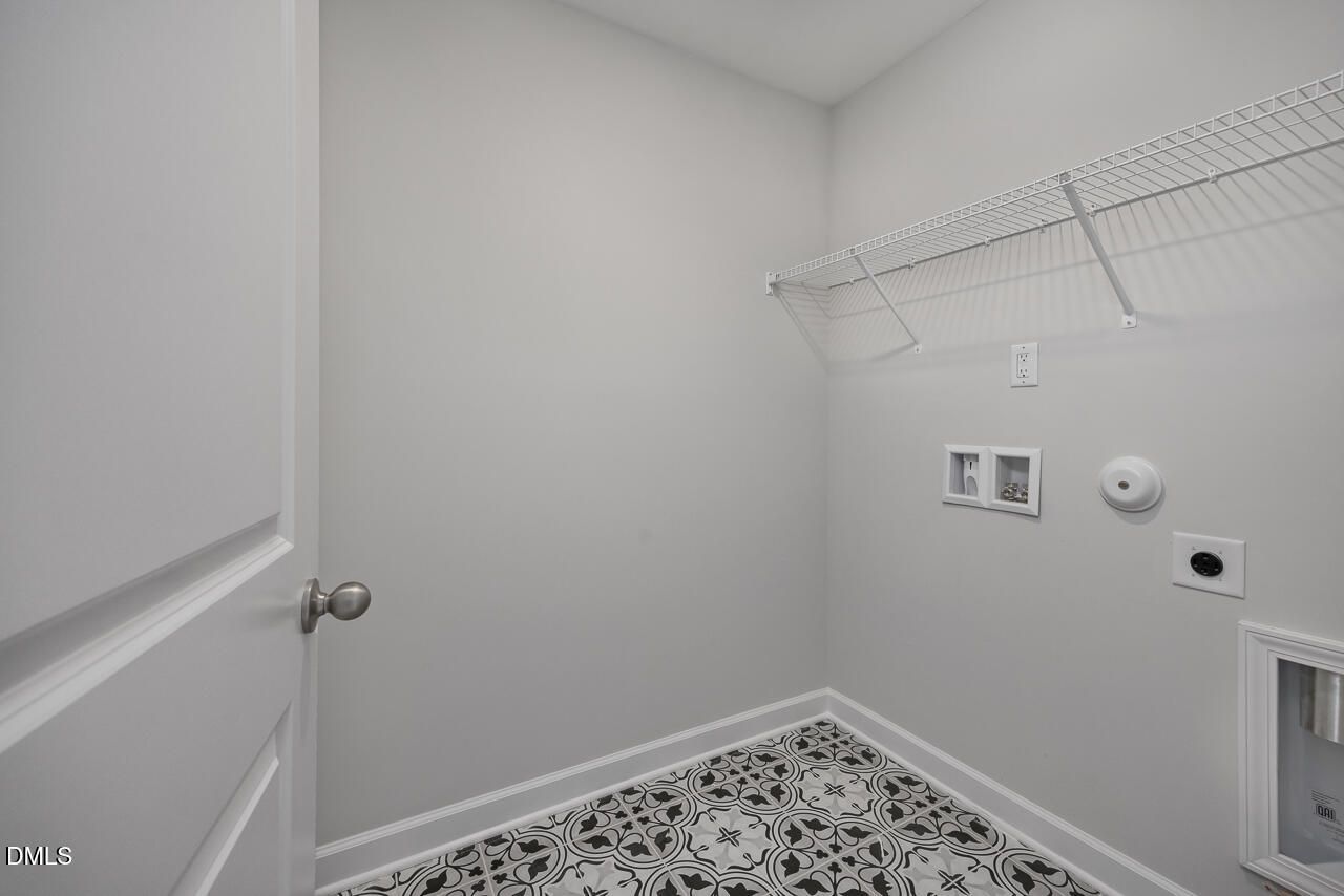 Laundry room with decorative tile flooring and wire shelving in The Adalynn B floor plan at Gregory Village, Lillington.