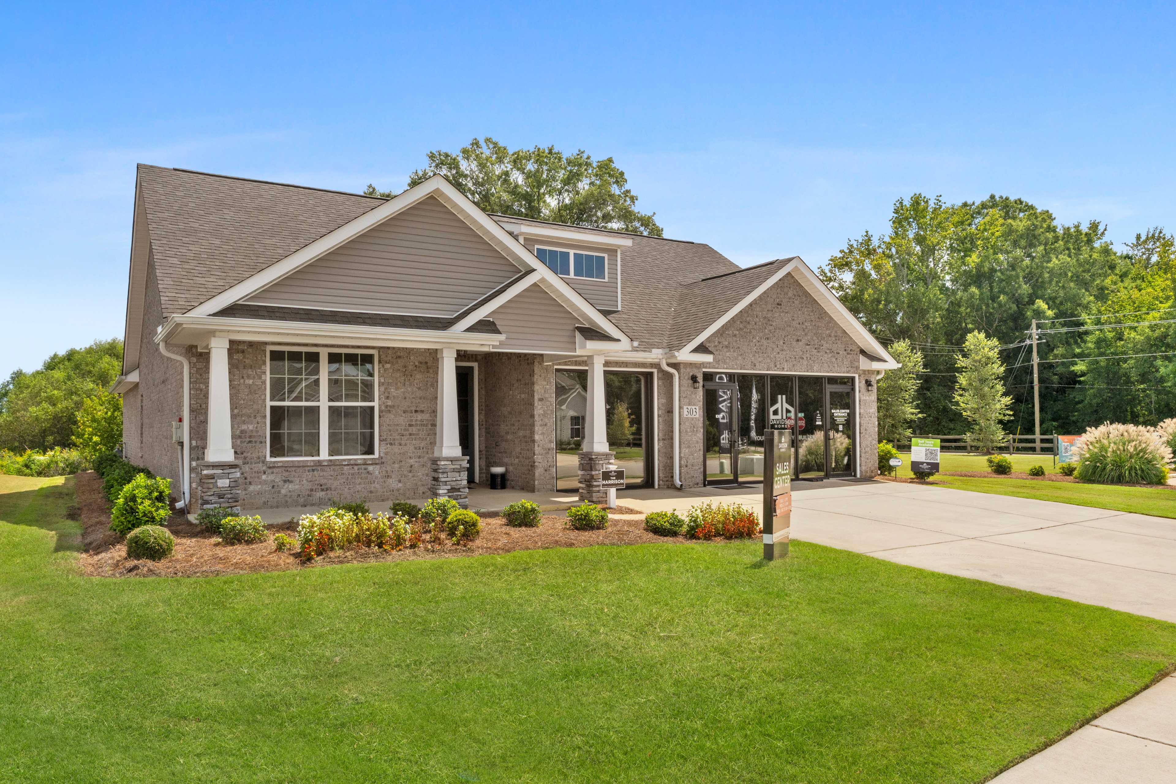 Contemporary ranch home exterior at Kendall Downs in Toney, Alabama with brick accents, covered porch and lush landscaping
